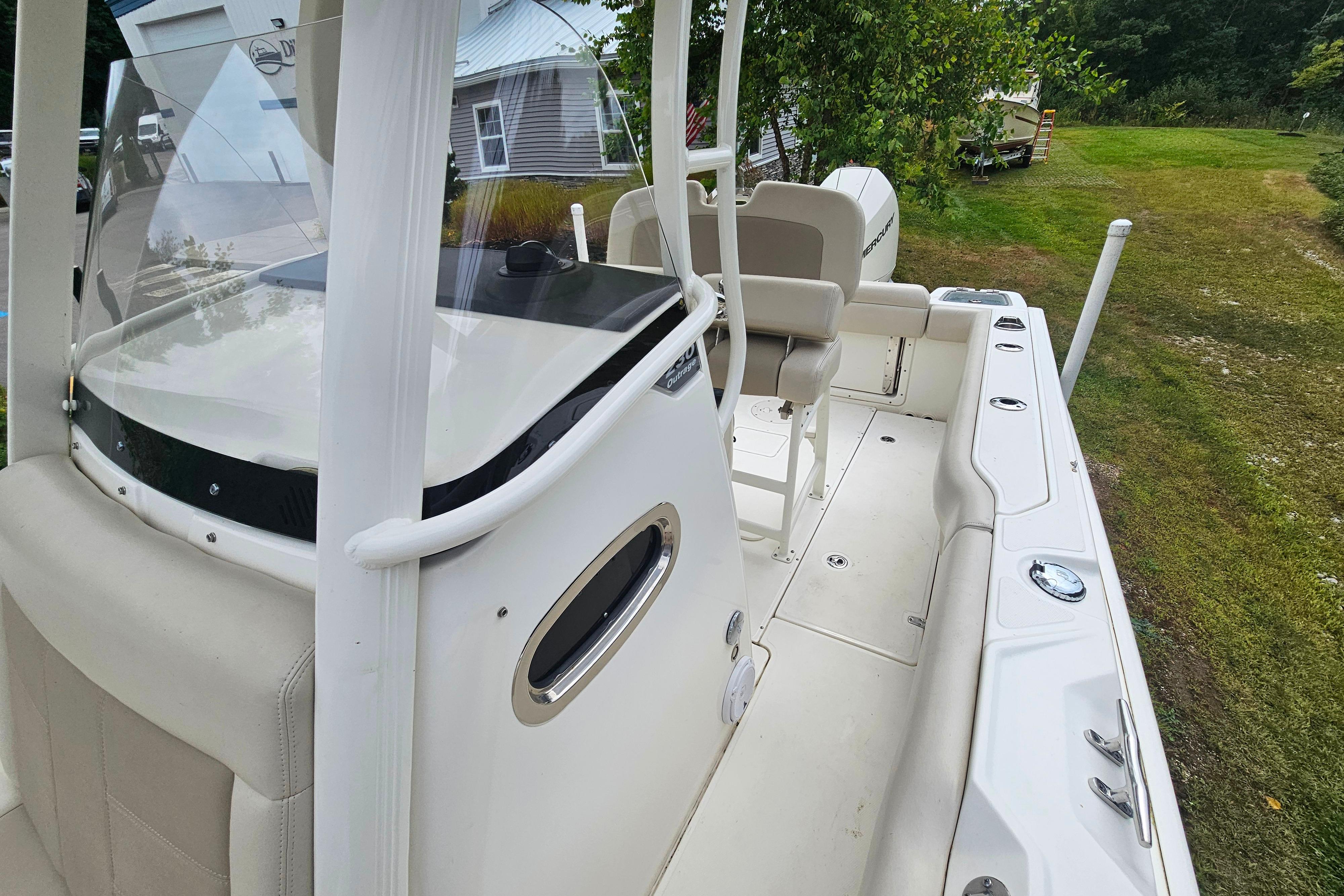 2019 Boston Whaler 230 Outrage boat interior with seating and console, parked on grass.