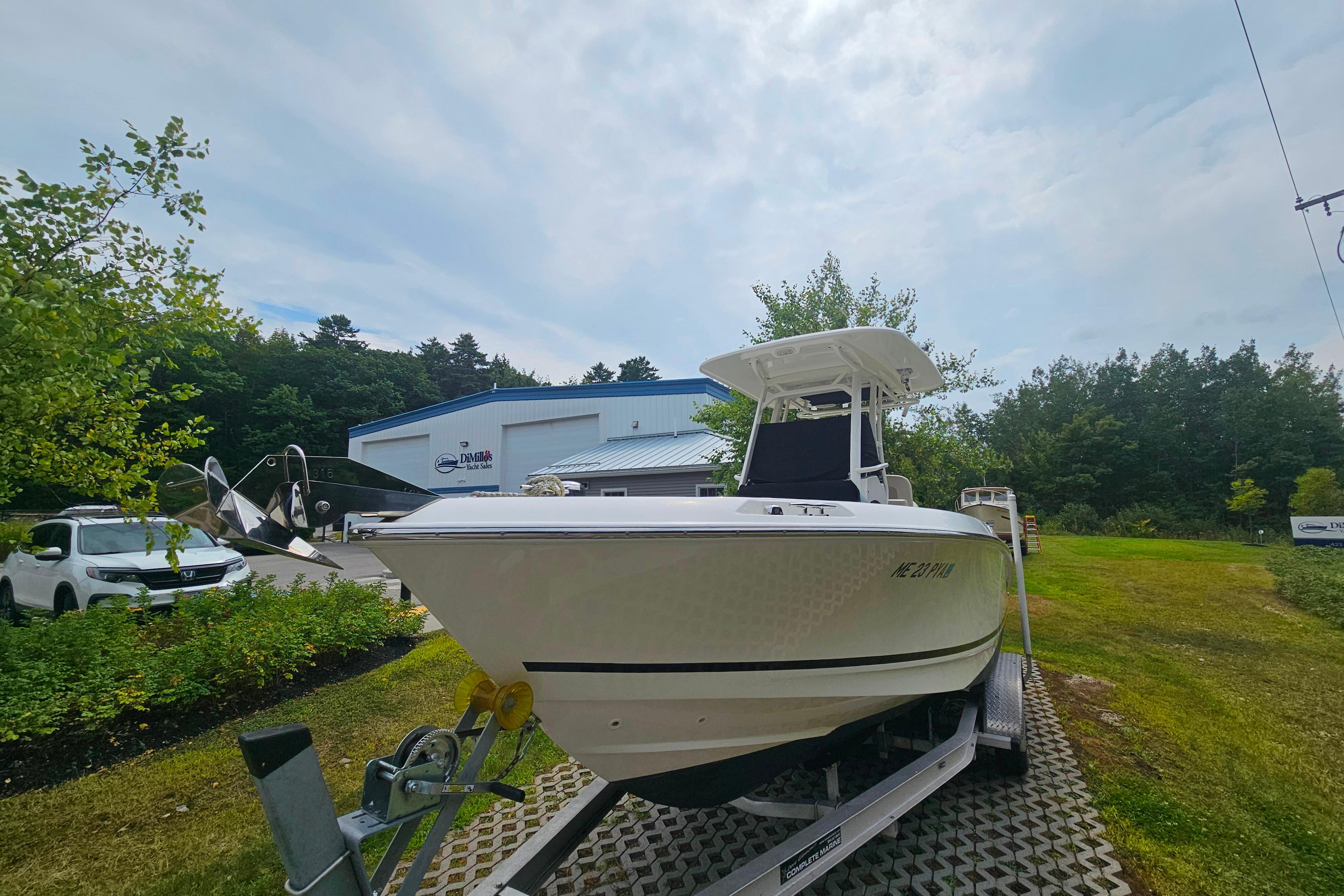 2019 Boston Whaler 230 Outrage boat on trailer, parked outdoors near a building.