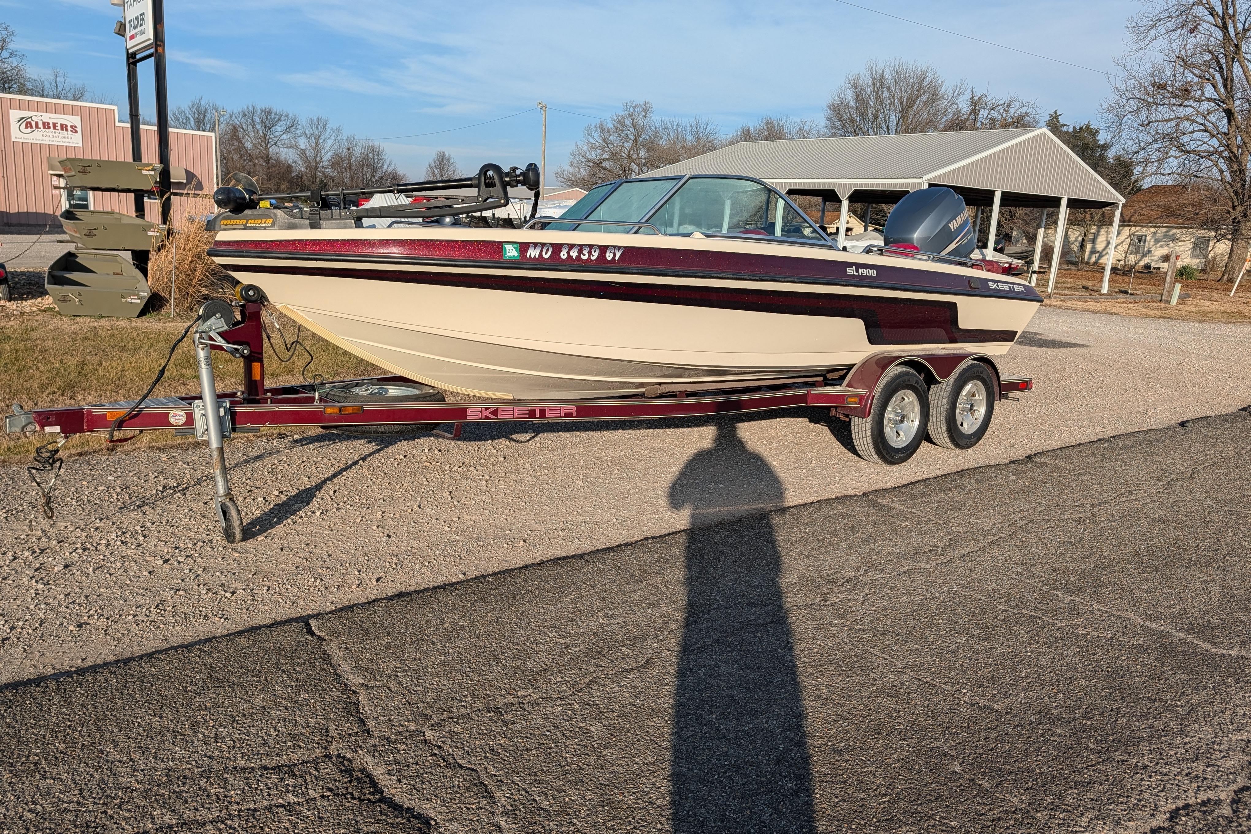 2009 Skeeter SL1900 boat on trailer, parked outdoors on a sunny day.