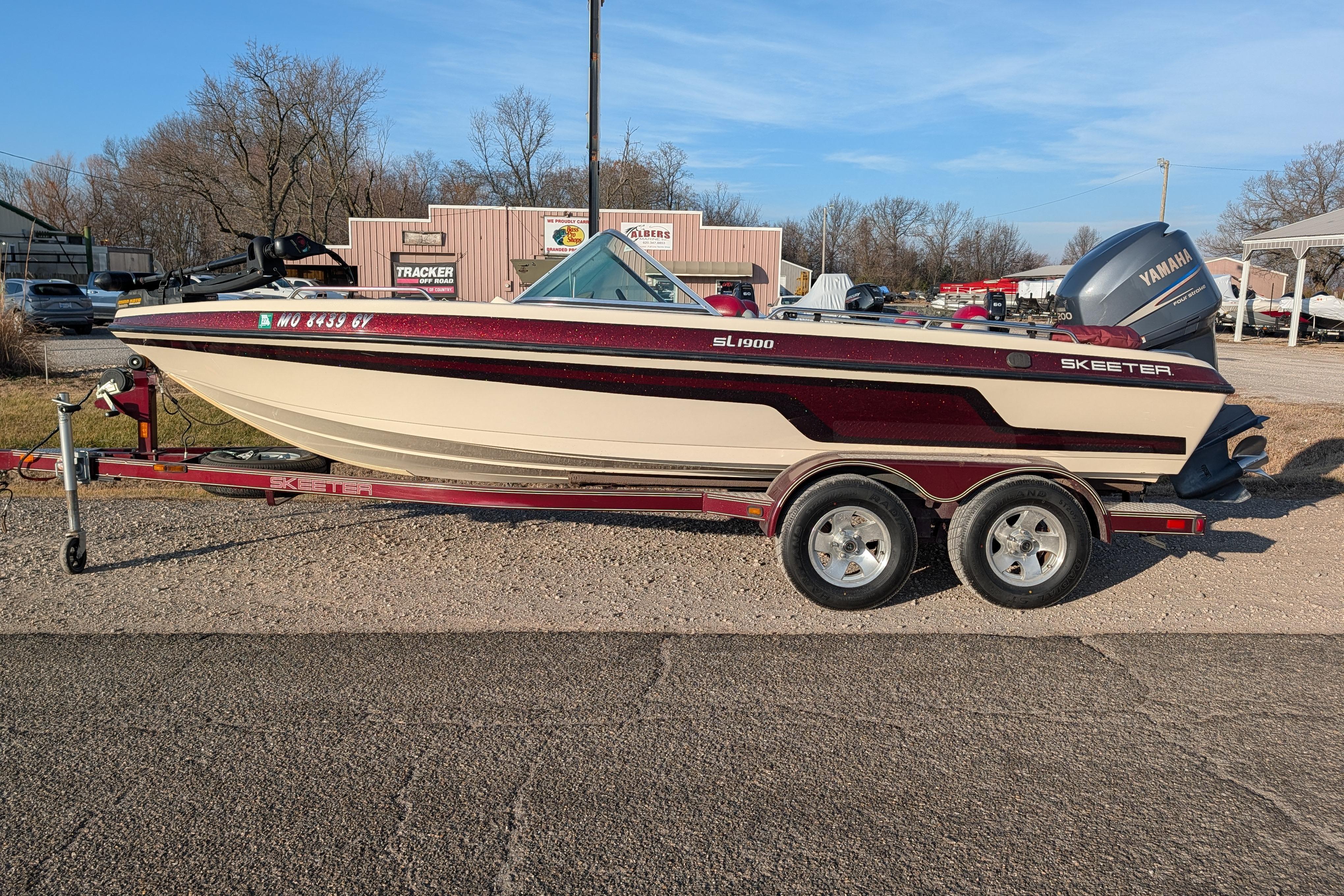 2009 Skeeter SL1900 boat on trailer with Yamaha outboard motor, parked outdoors.