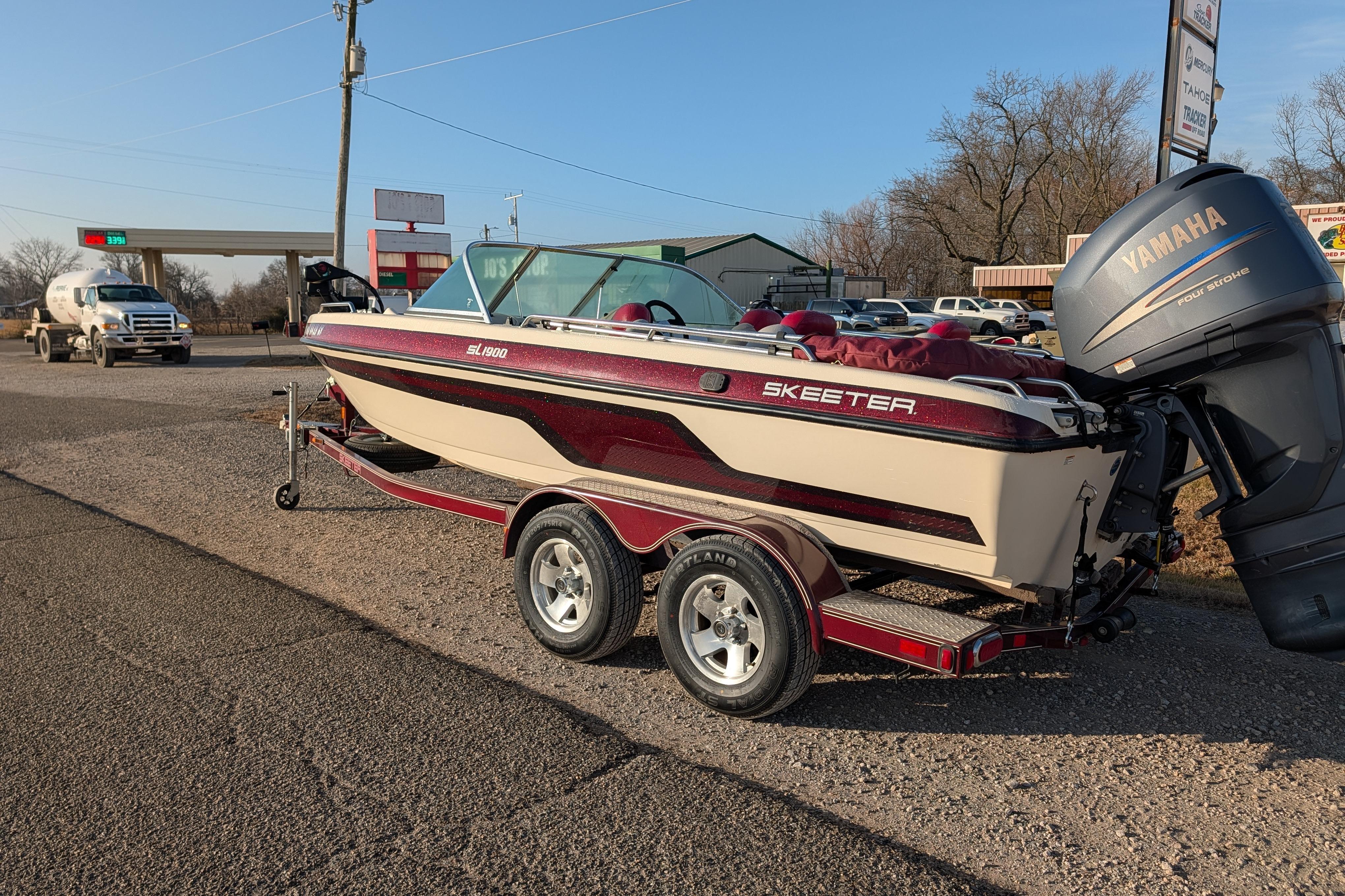 2009 Skeeter SL1900 boat on trailer with Yamaha outboard motor in parking lot.