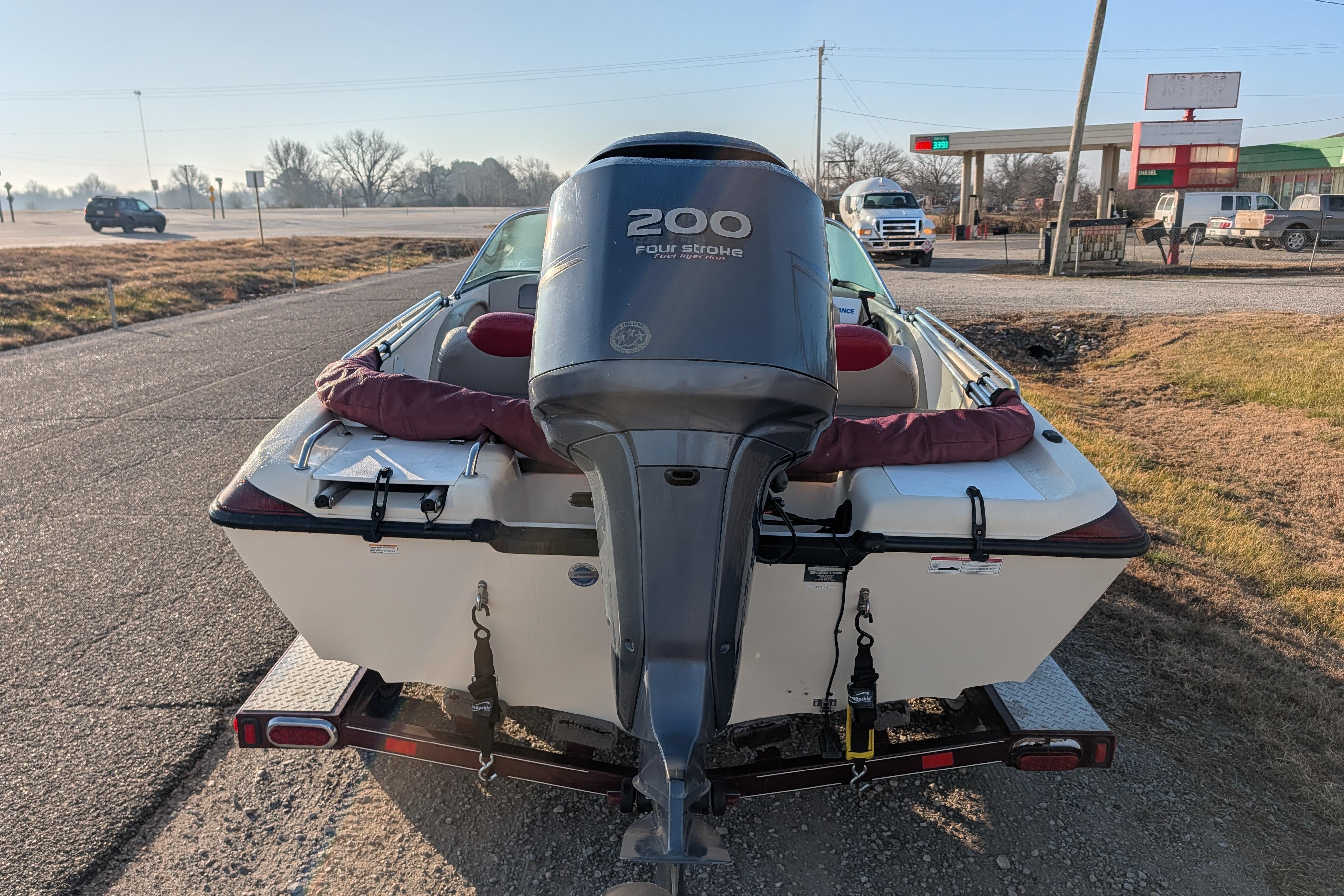 2009 Skeeter SL1900 boat with 200 horsepower engine on trailer, parked roadside.