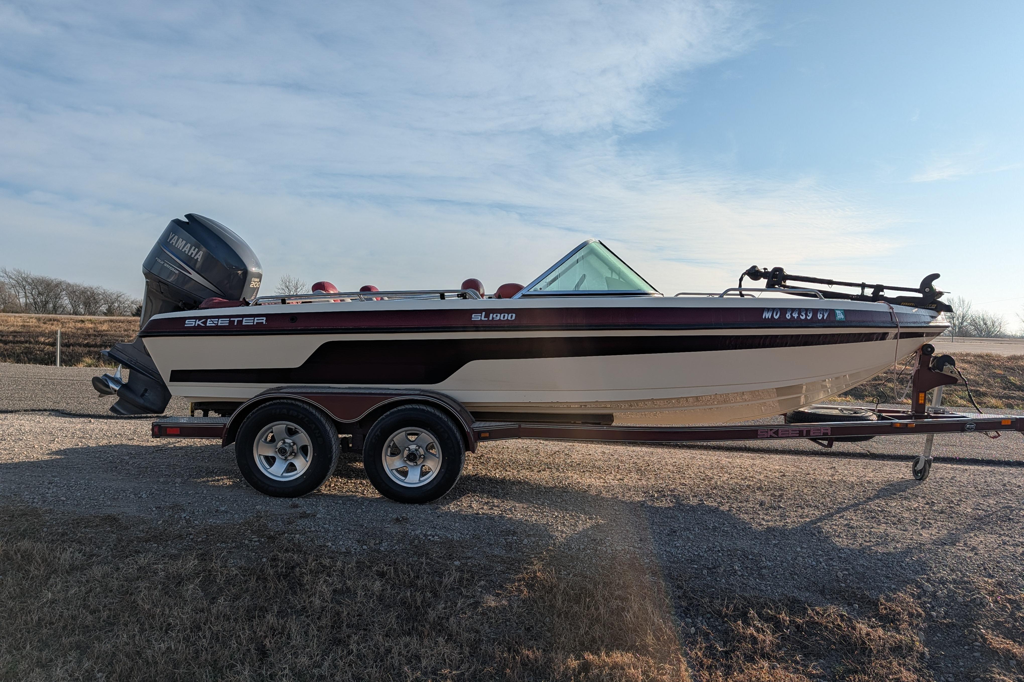 2009 Skeeter SL1900 boat on trailer with Yamaha outboard motor, parked outdoors.