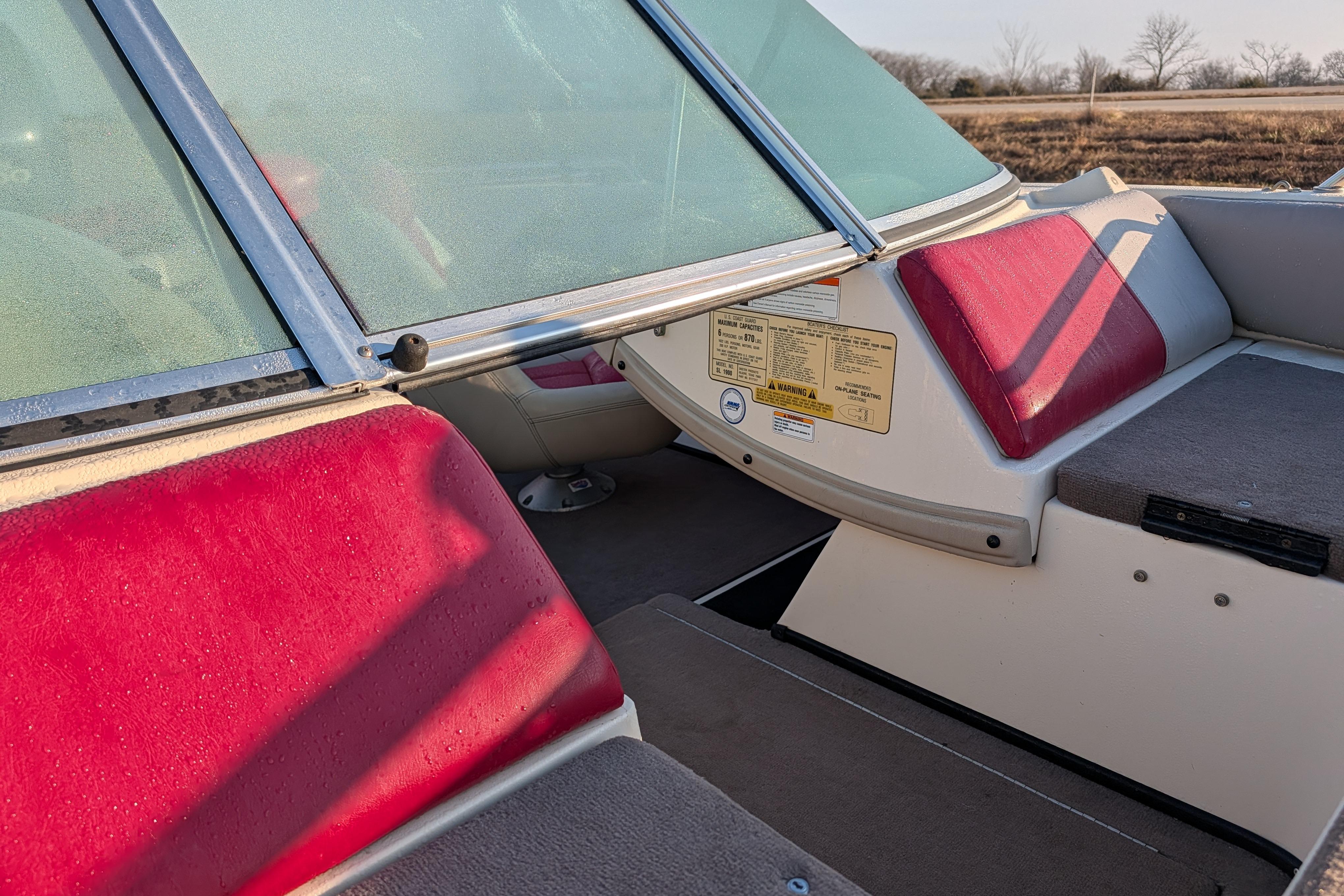 2009 Skeeter SL1900 boat interior with red and gray seating, windshield, and safety labels.