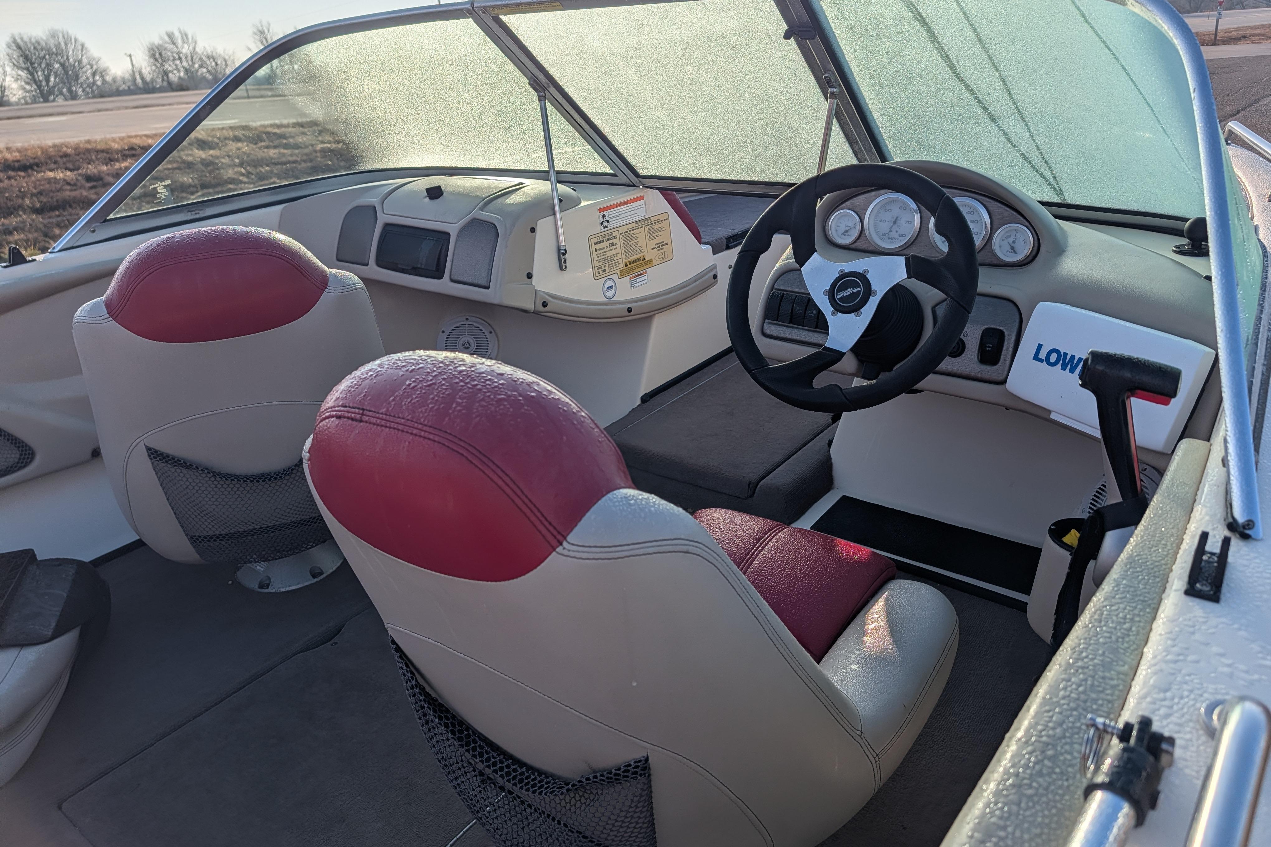 2009 Skeeter SL1900 boat interior with red and white seats, steering wheel, and dashboard.