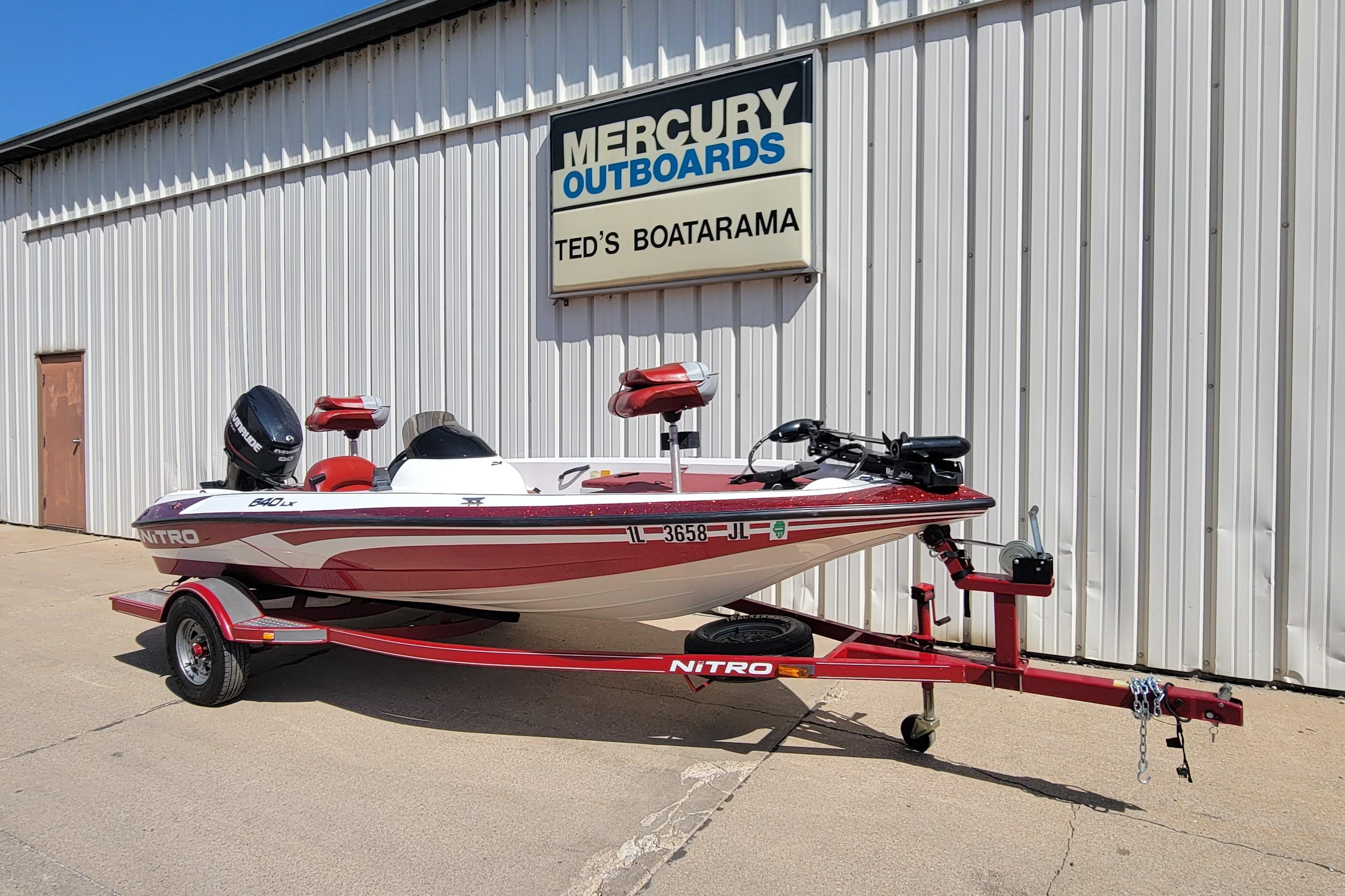 Red 2000 Nitro 640LX boat on trailer outside Mercury Outboards dealership.