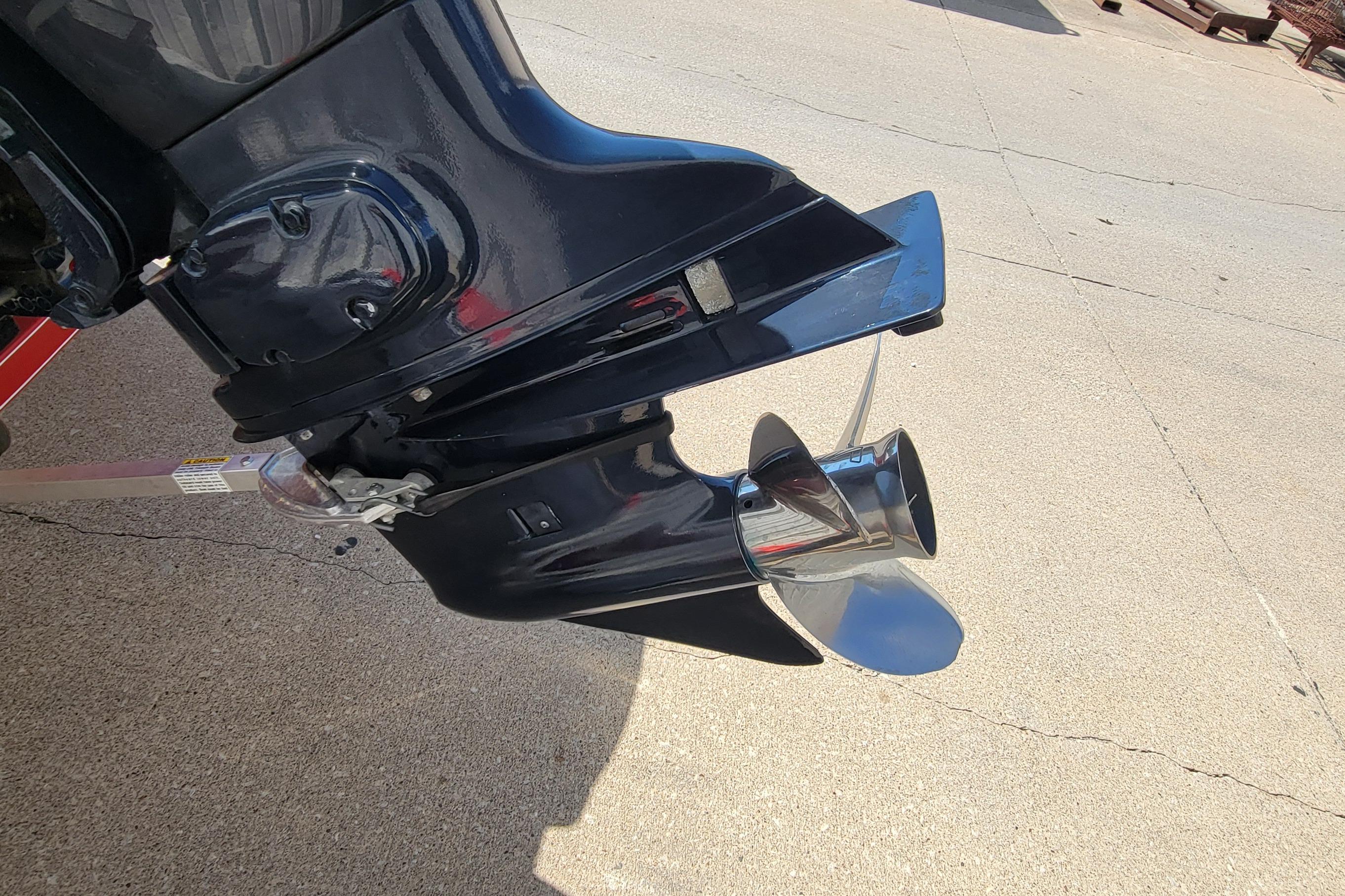 Outboard motor propeller of a 2000 Nitro 640LX boat on concrete surface.