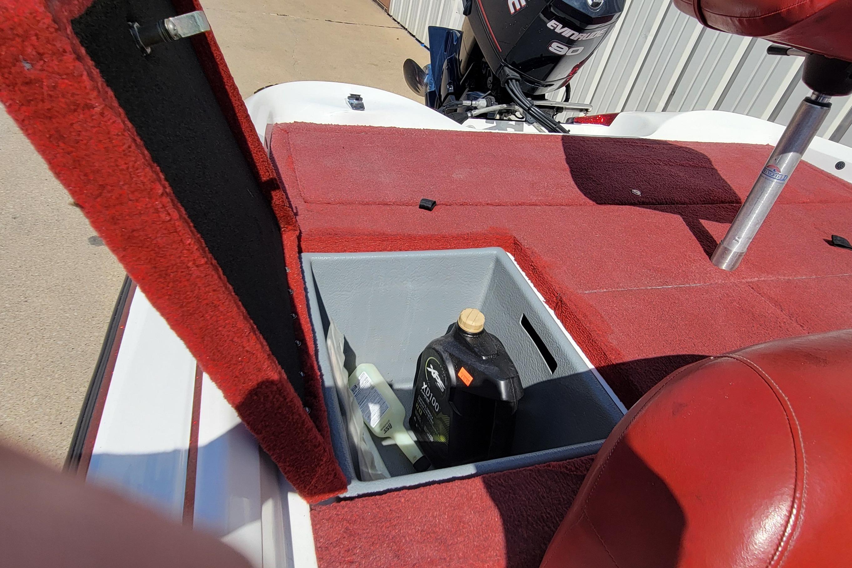Open storage compartment on 2000 Nitro 640LX boat with red carpet and engine in background.