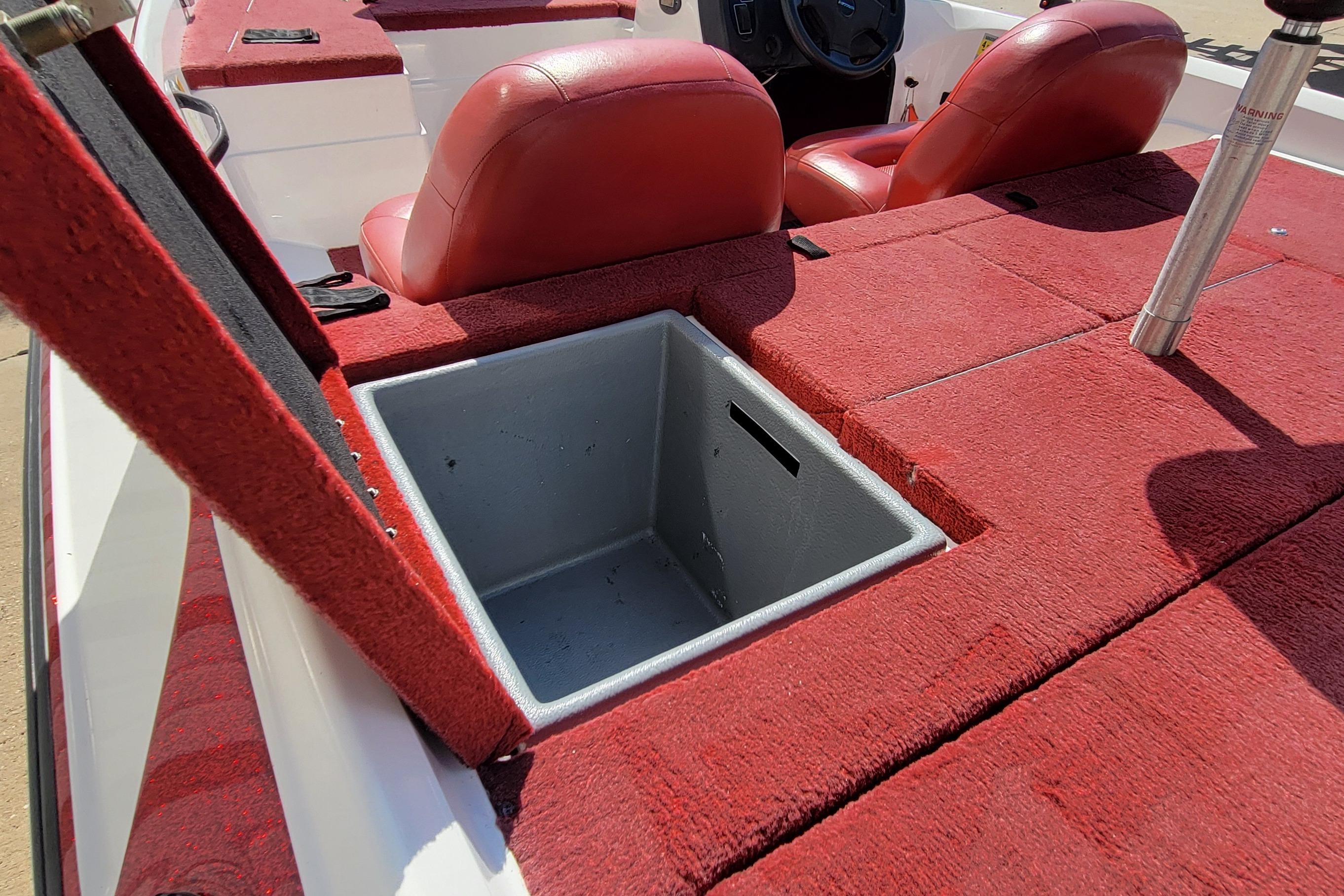 Red interior of 2000 Nitro 640LX boat with open storage compartment.