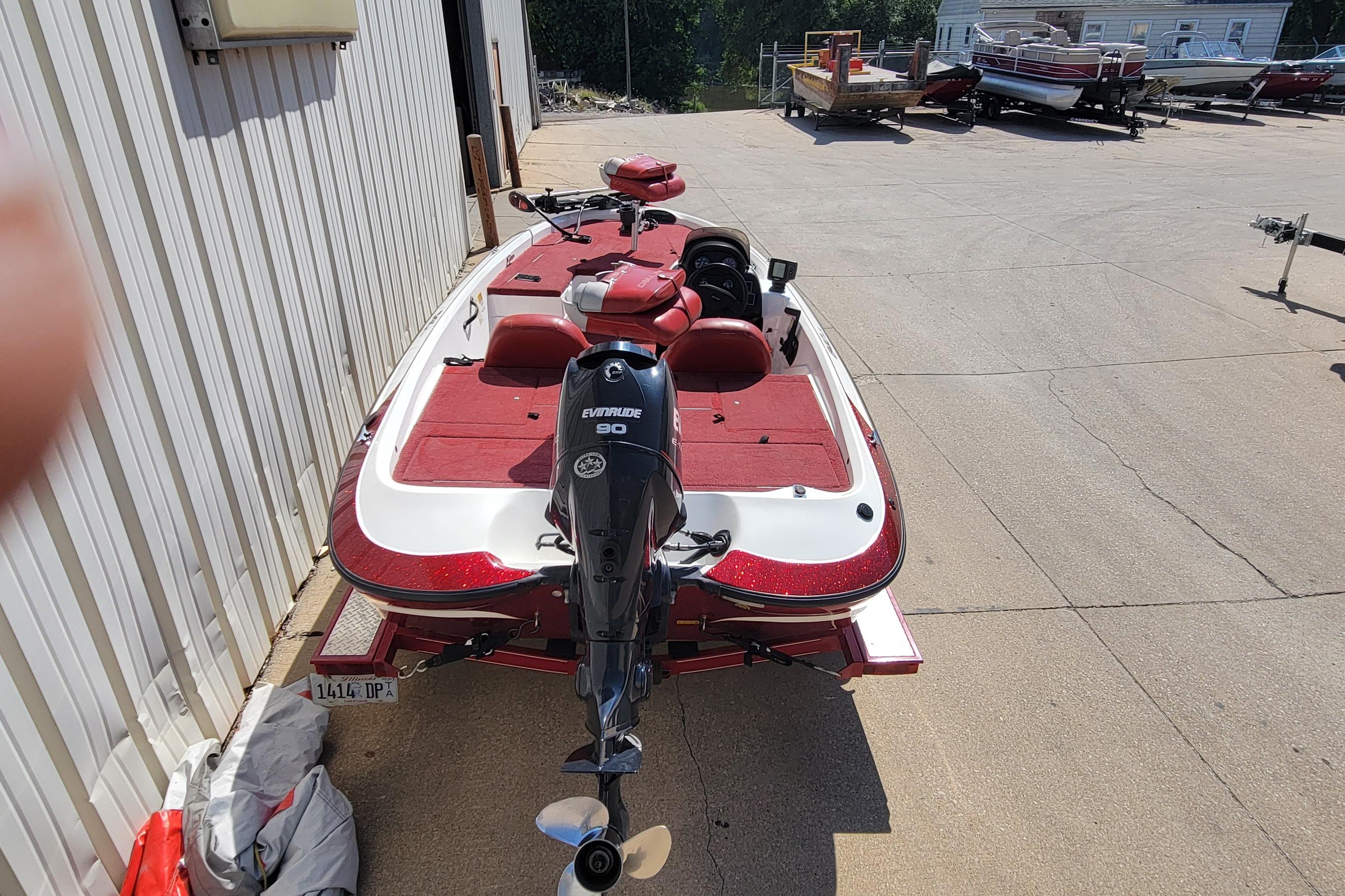 2000 Nitro 640LX boat with Evinrude 90 engine, parked outdoors on concrete.