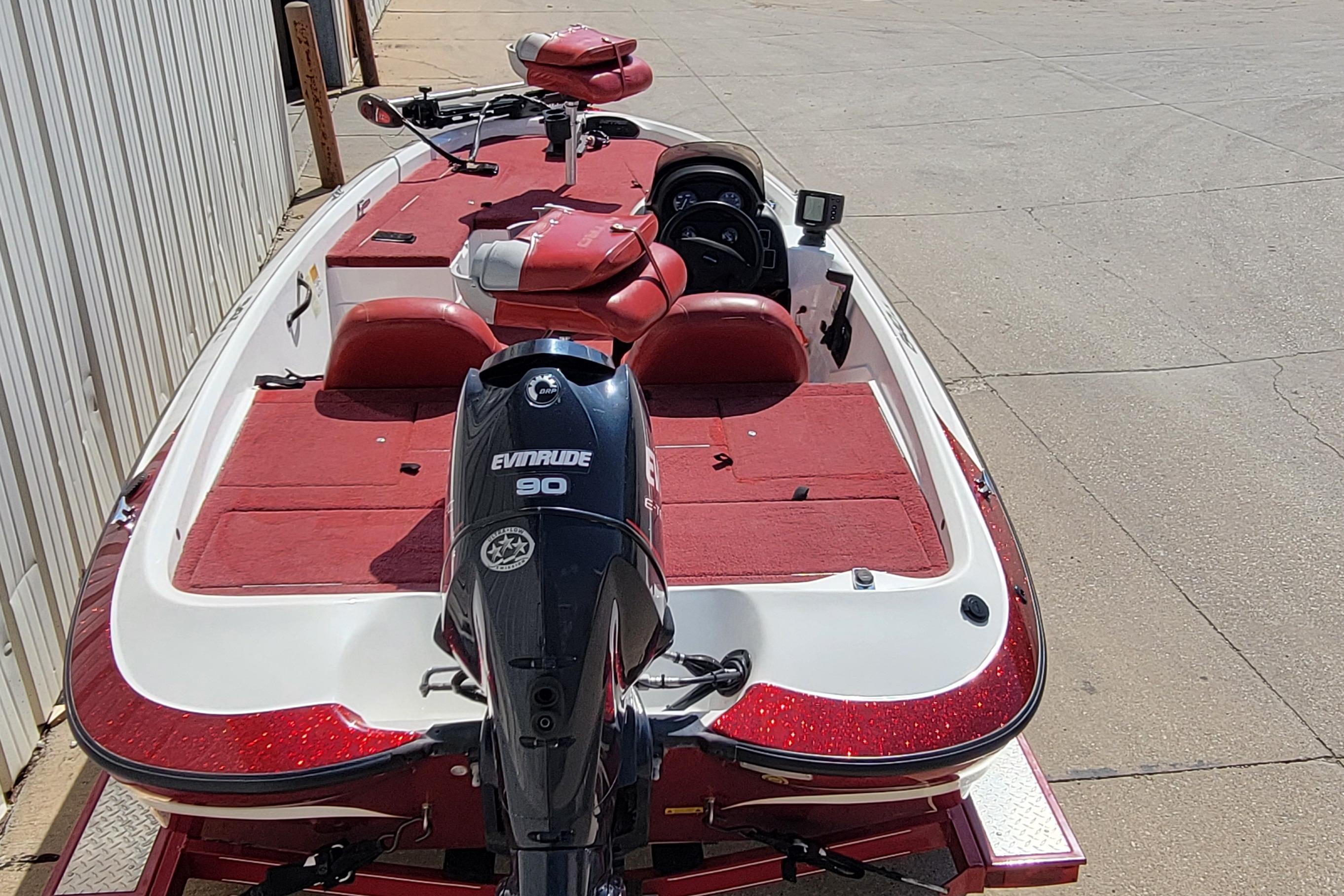 2000 Nitro 640LX boat with Evinrude 90 engine, red and white design, parked outdoors.