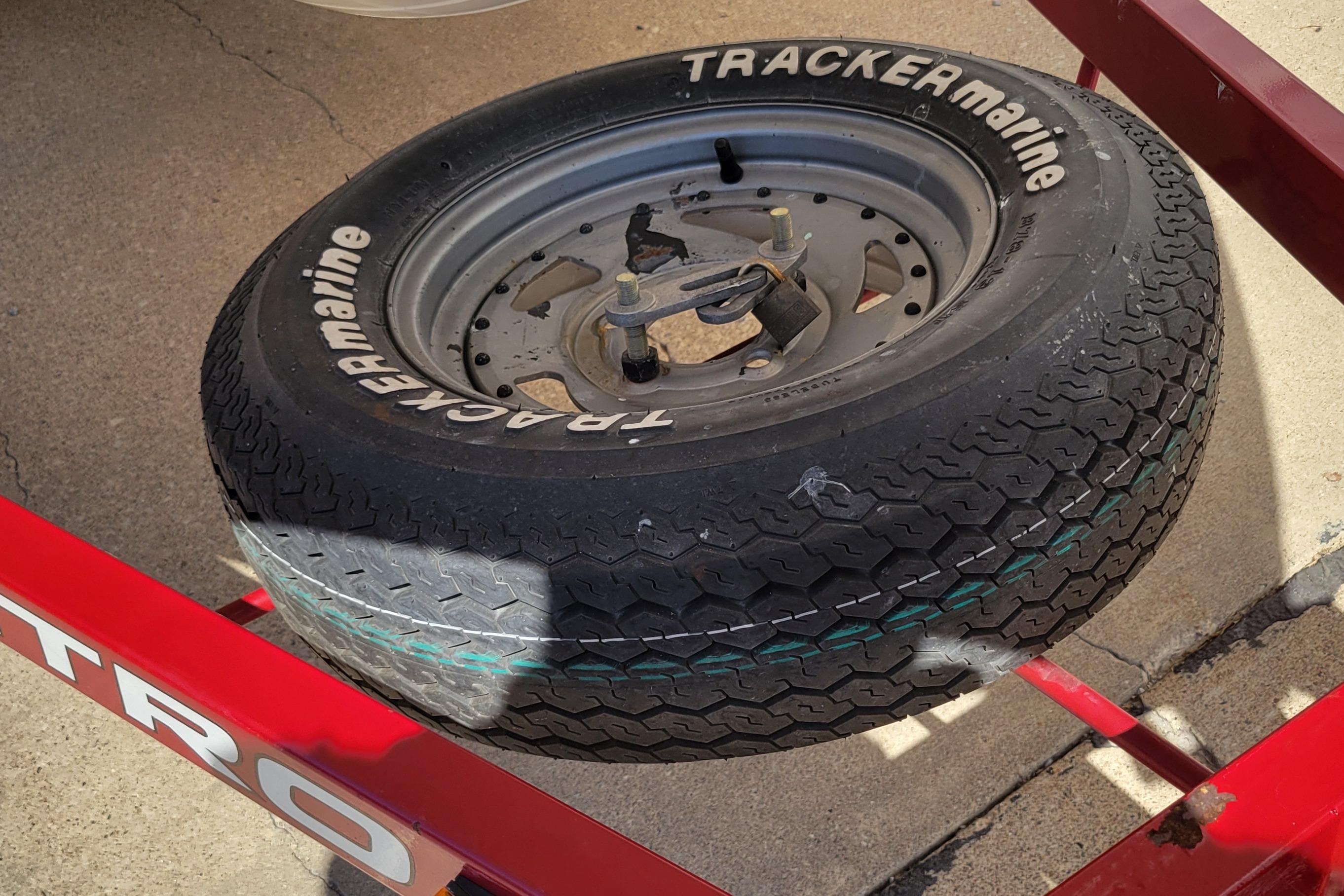 Spare tire on a 2000 Nitro 640LX trailer, featuring Tracker Marine branding.