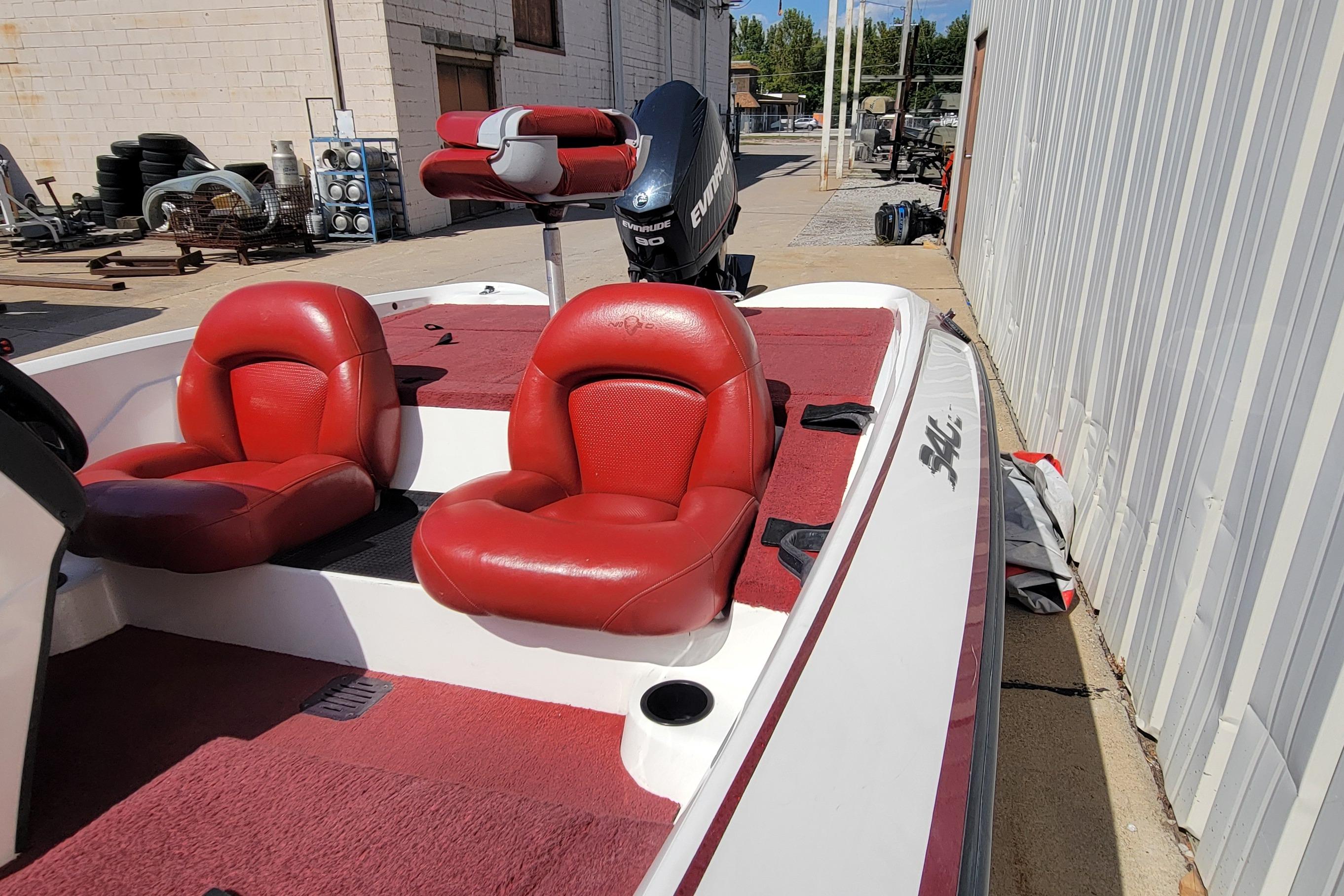 2000 Nitro 640LX boat with red seats and Evinrude motor, docked outdoors.