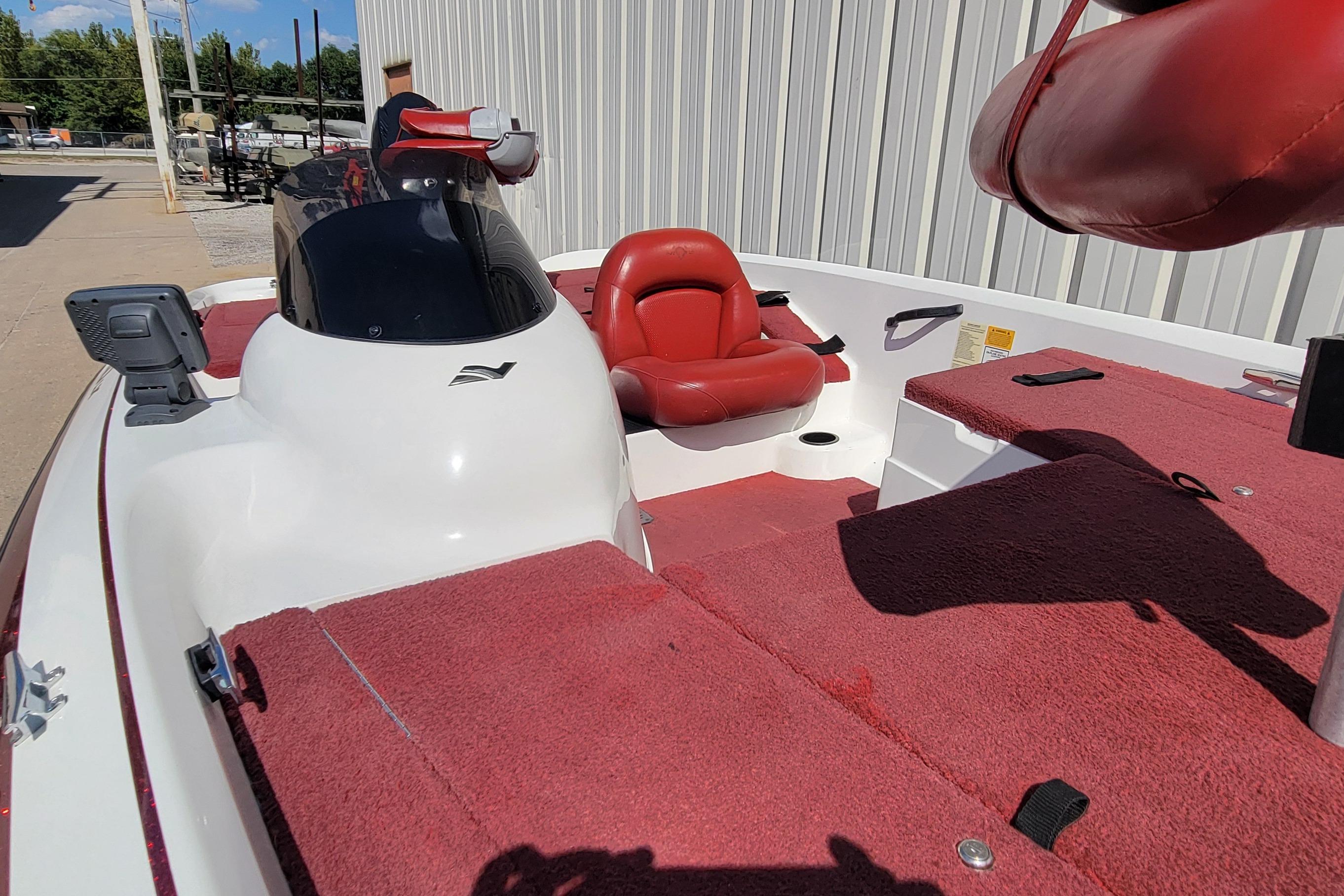 2000 Nitro 640LX boat with red interior and white exterior, docked outdoors.