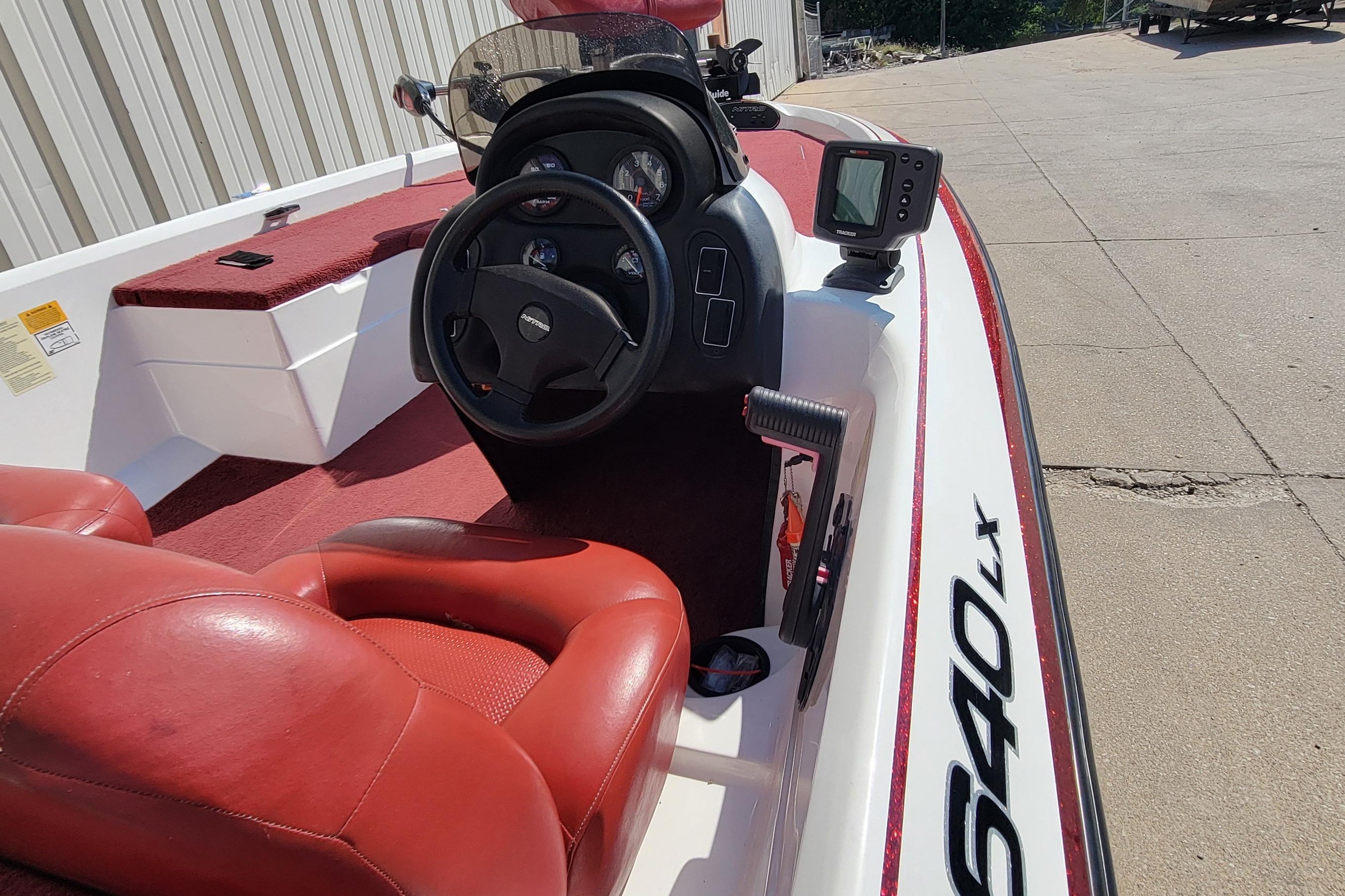 2000 Nitro 640LX boat interior with red seats and steering console.