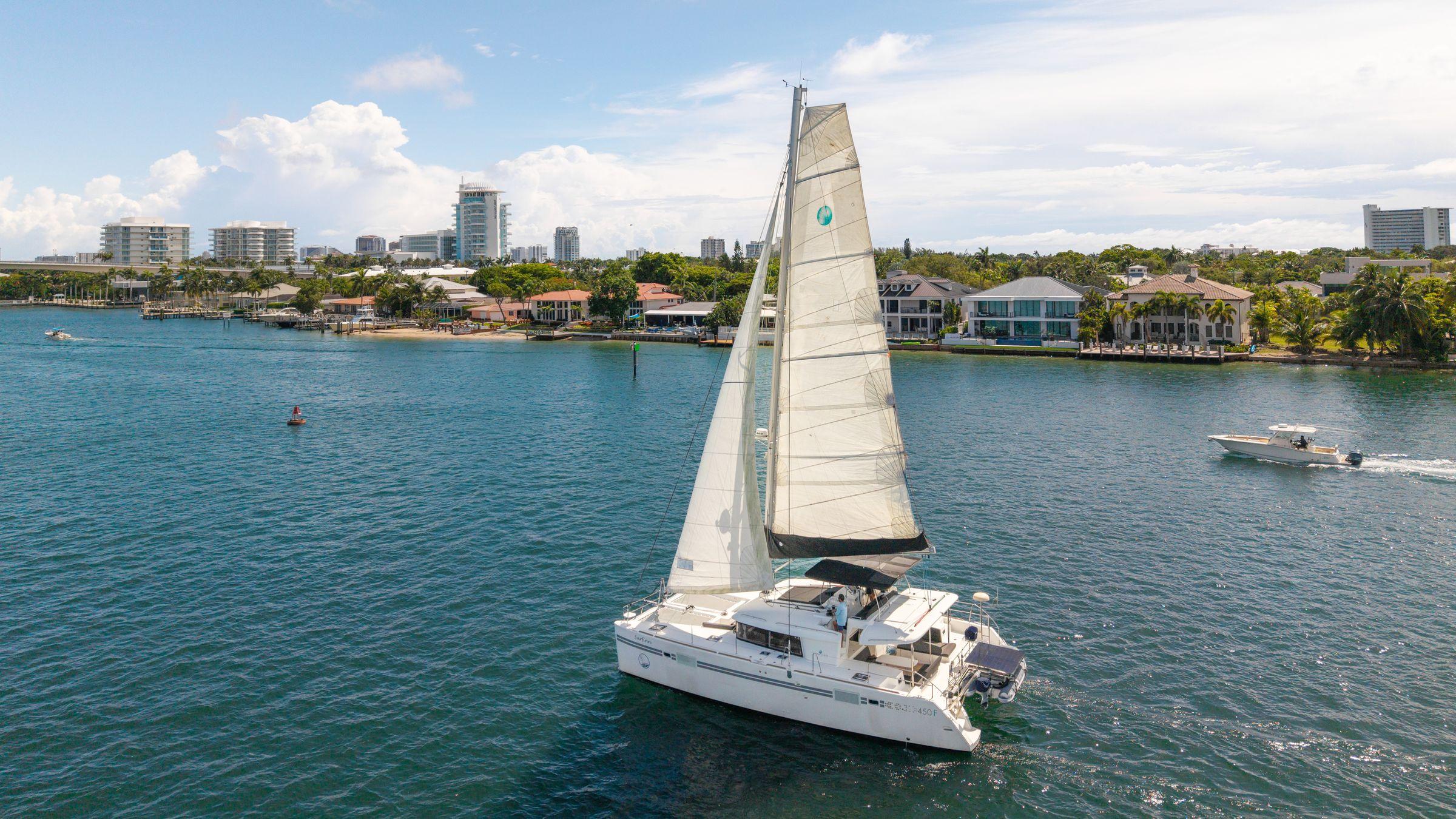 Picture of Cruisin Cajun Lagoon 45.83 ft' 450 F 2017 Lagoon 450 F catamaran sailing near coastal cityscape. 