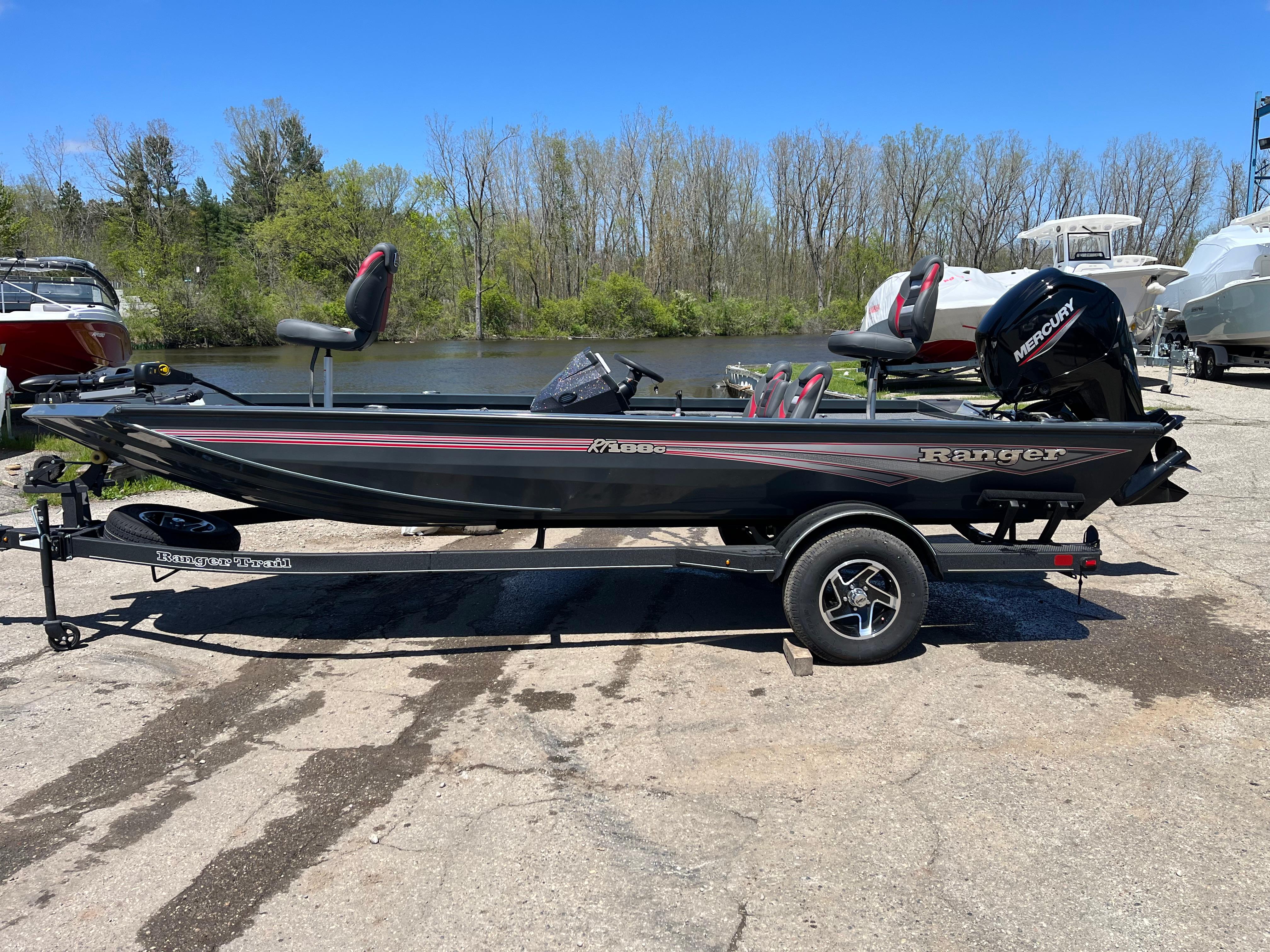 2024 Ranger RT188C fishing boat on trailer, parked near a lake with trees in the background.