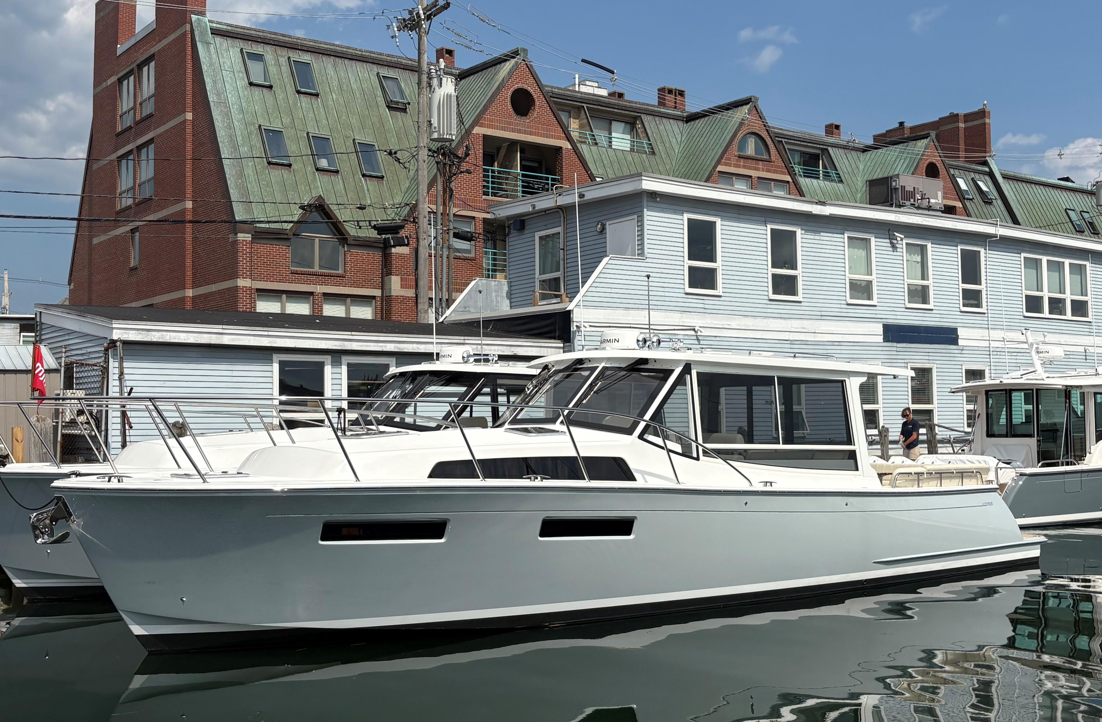 2026 MJM 47R yacht docked near buildings under a clear sky.
