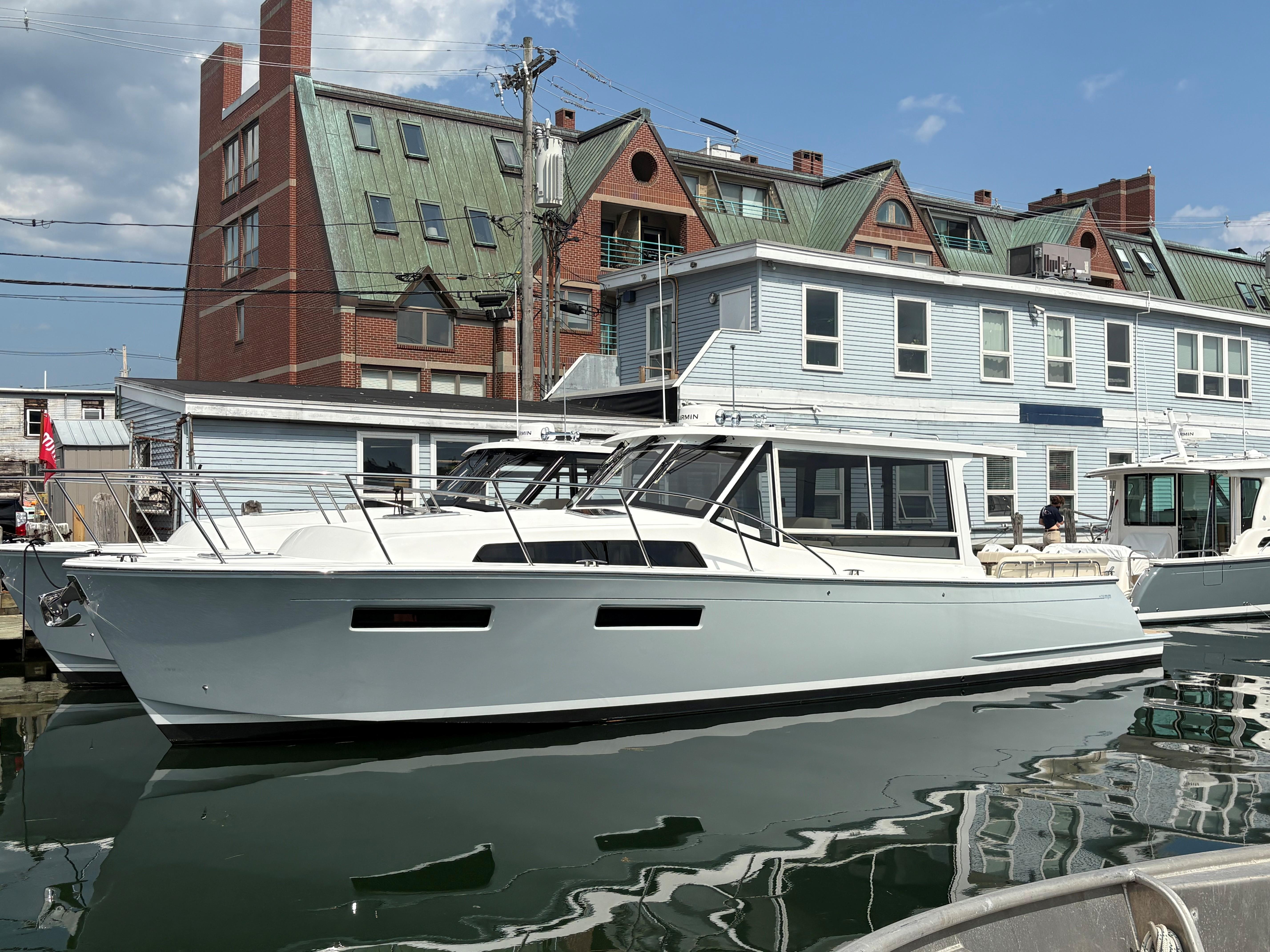 2026 MJM 47R yacht docked at marina, modern design, clear sky background.