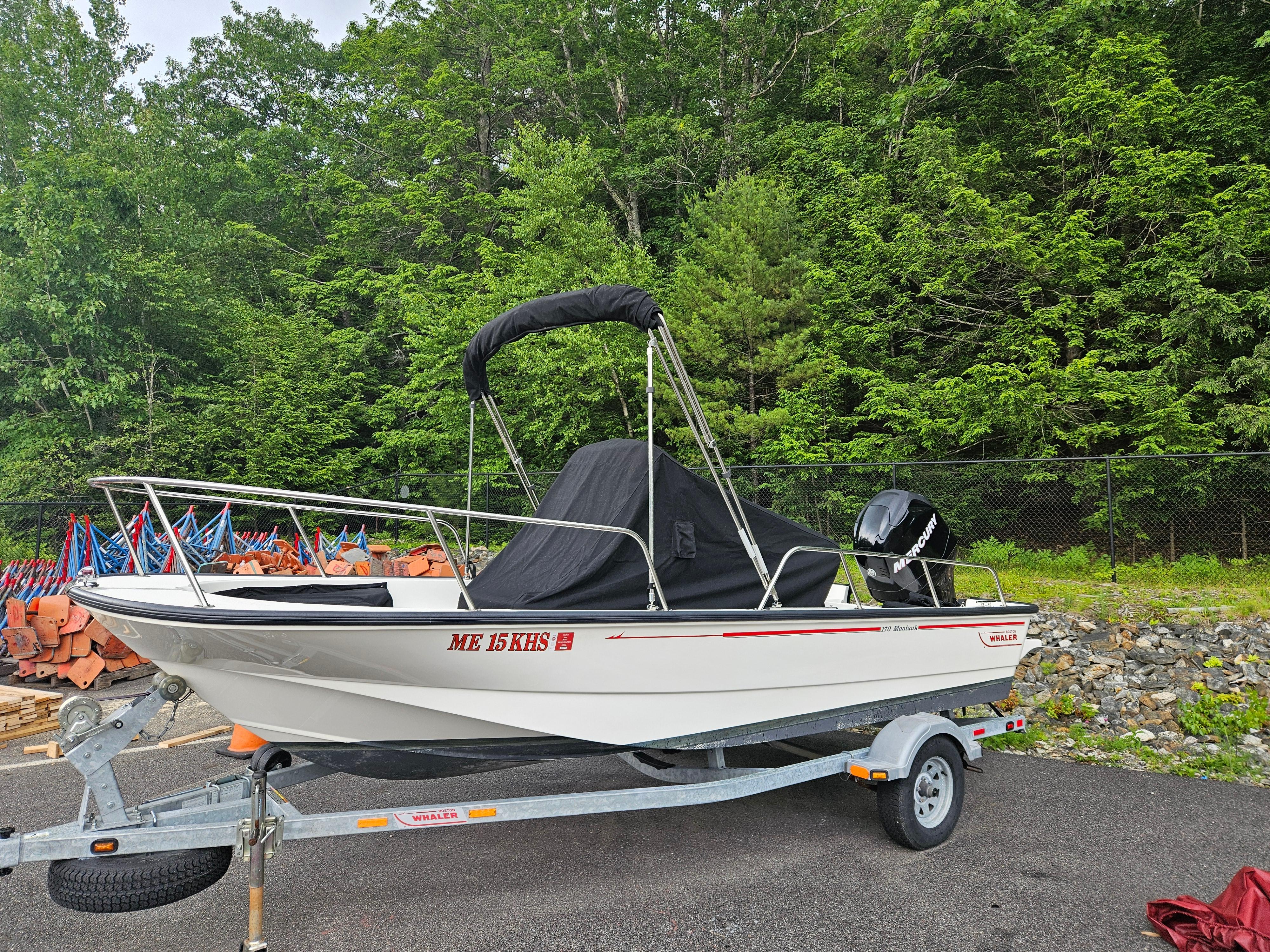 2008 Boston Whaler 170 Montauk boat on trailer, surrounded by lush greenery.