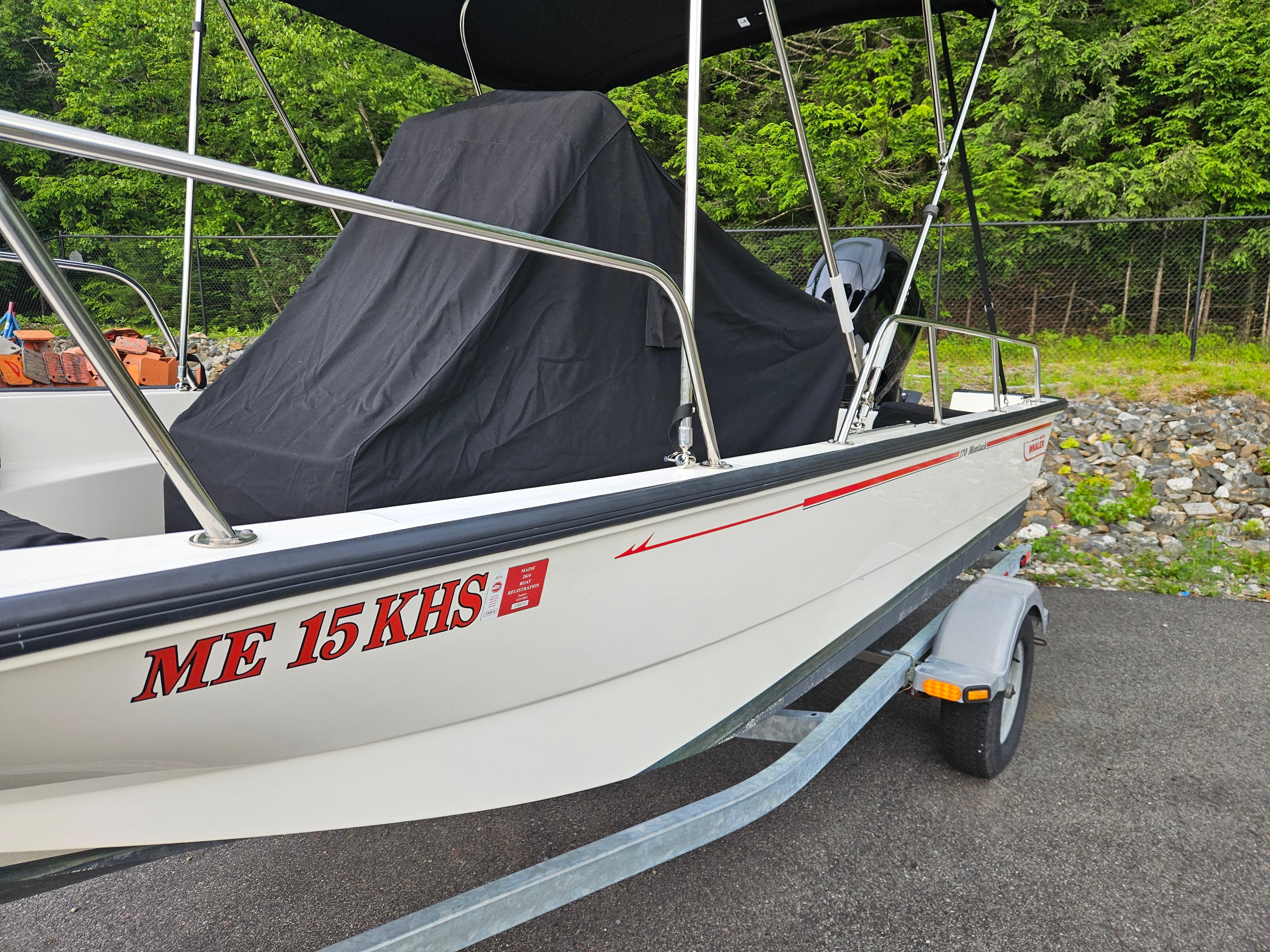2008 Boston Whaler 170 Montauk boat on trailer, covered, parked on asphalt.
