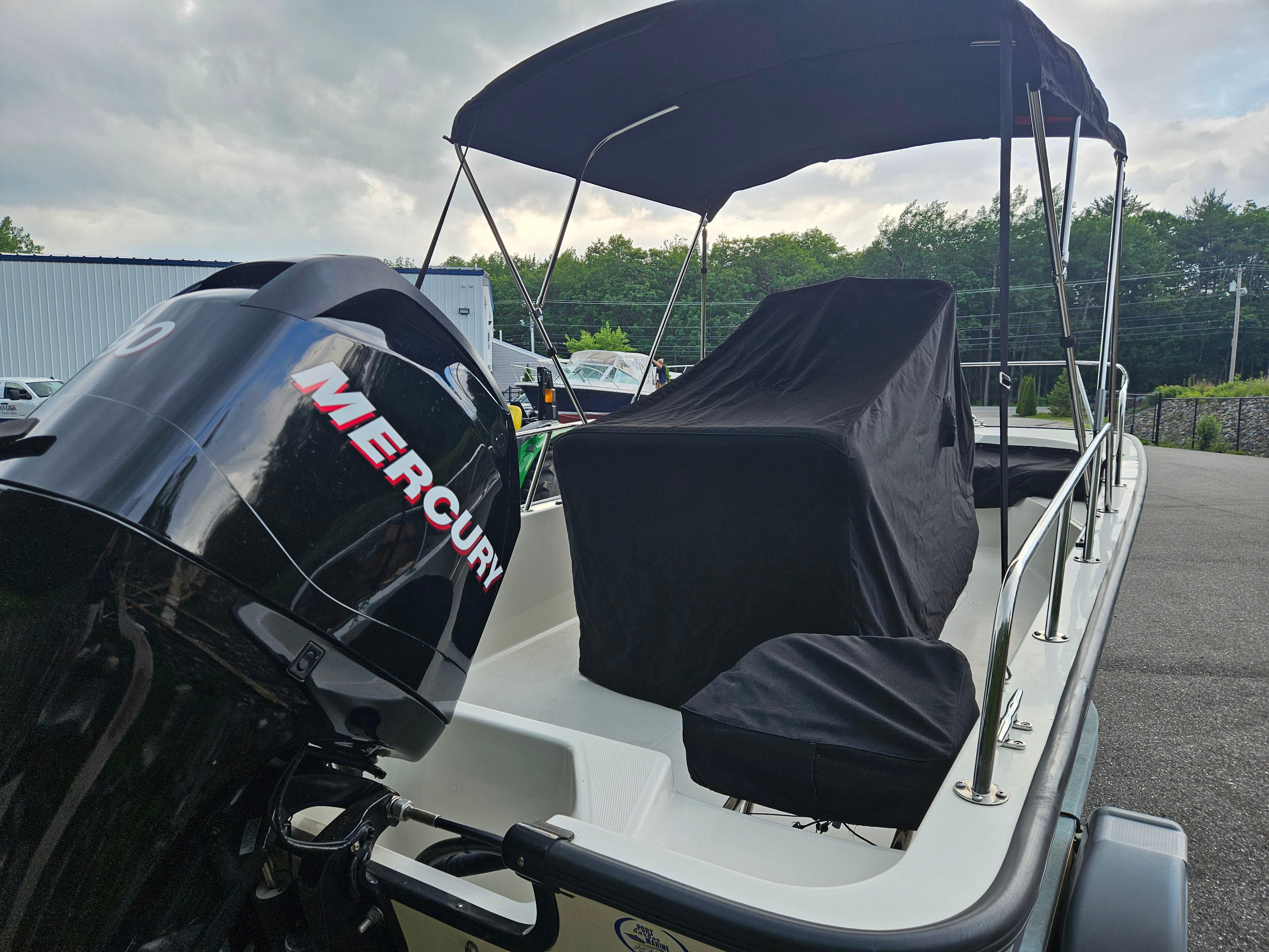 2008 Boston Whaler 170 Montauk boat with Mercury engine, covered seats, and canopy.
