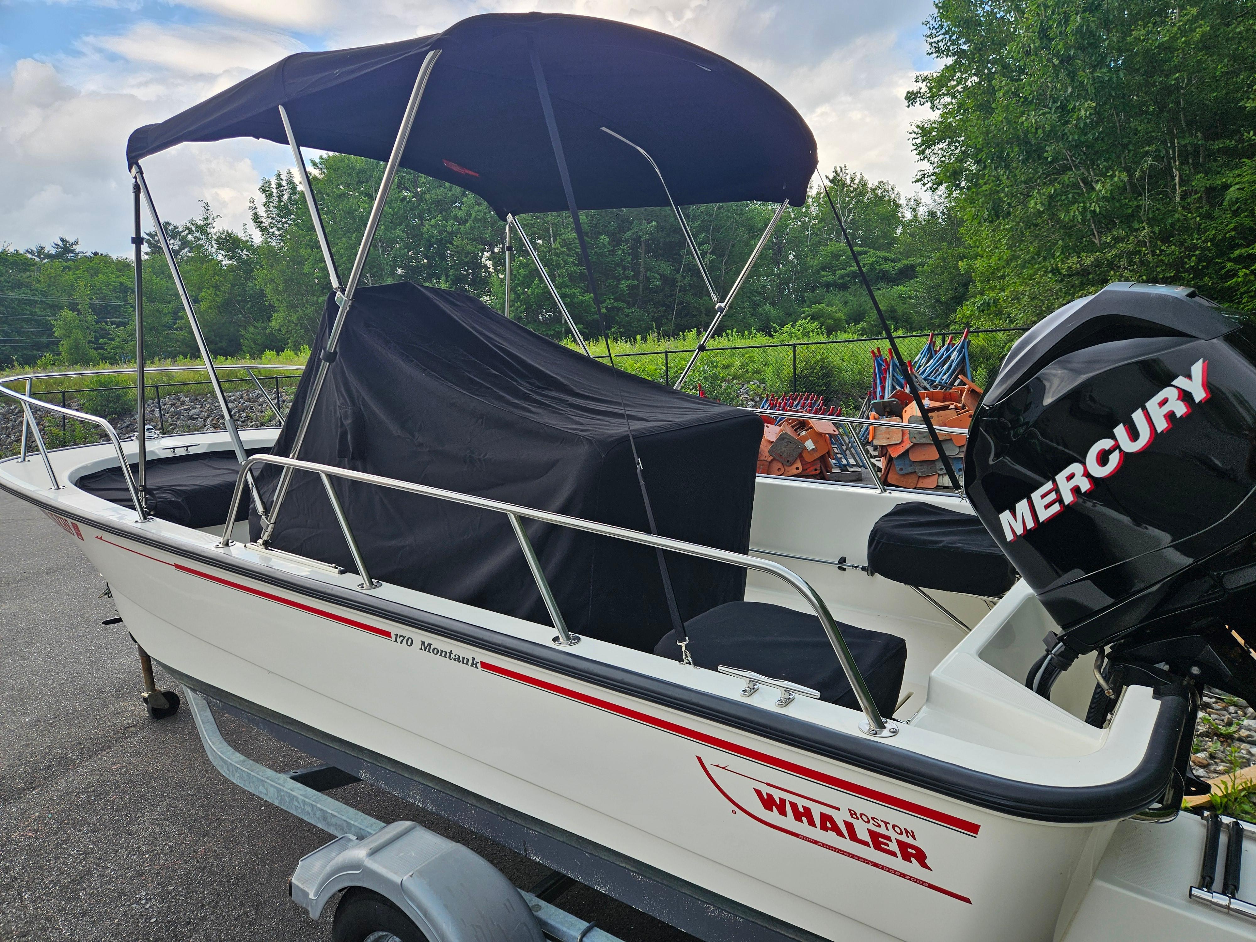 2008 Boston Whaler 170 Montauk boat with Mercury engine, parked on a trailer.