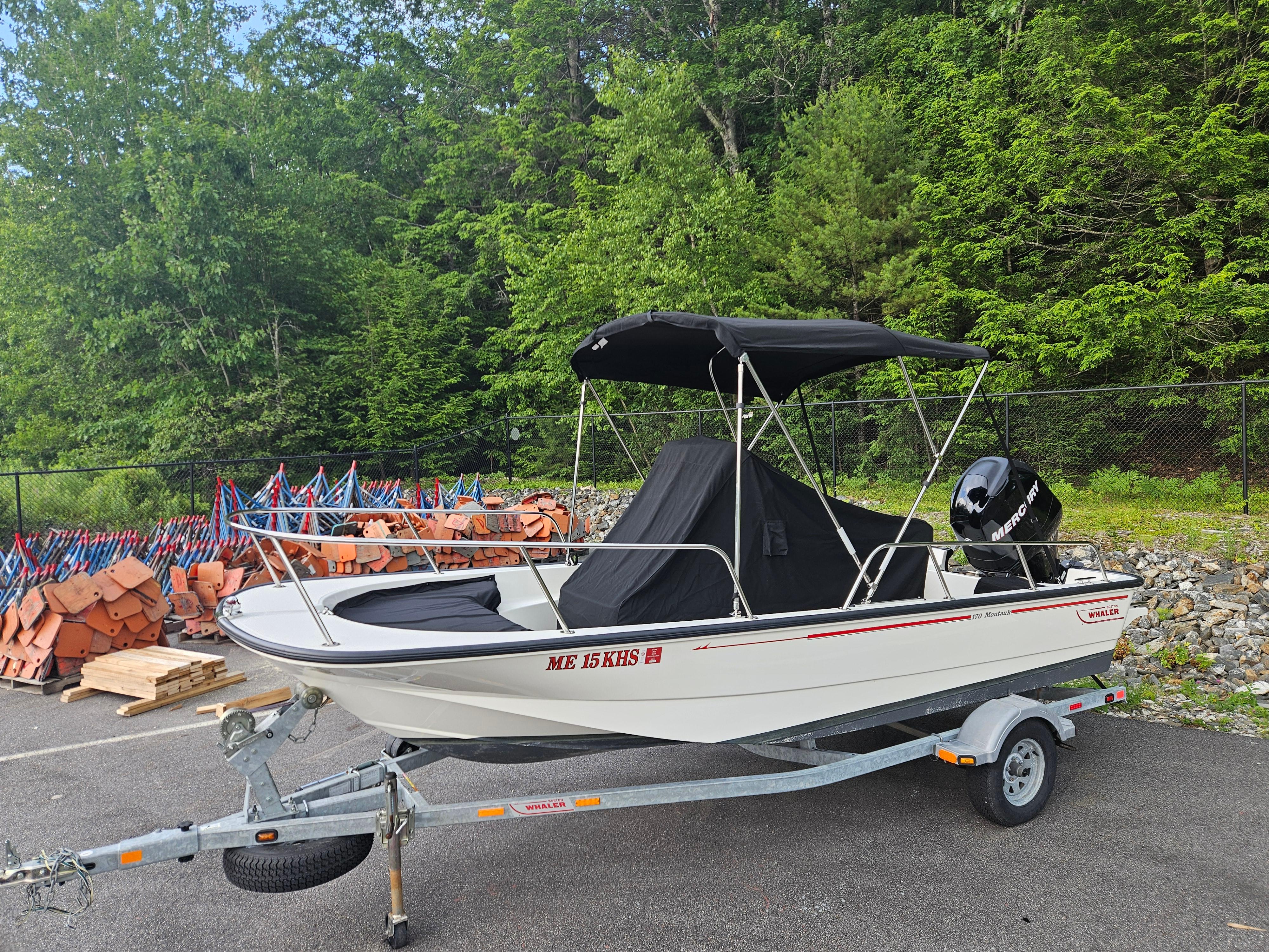 2008 Boston Whaler 170 Montauk boat on trailer, parked outdoors with trees in background.