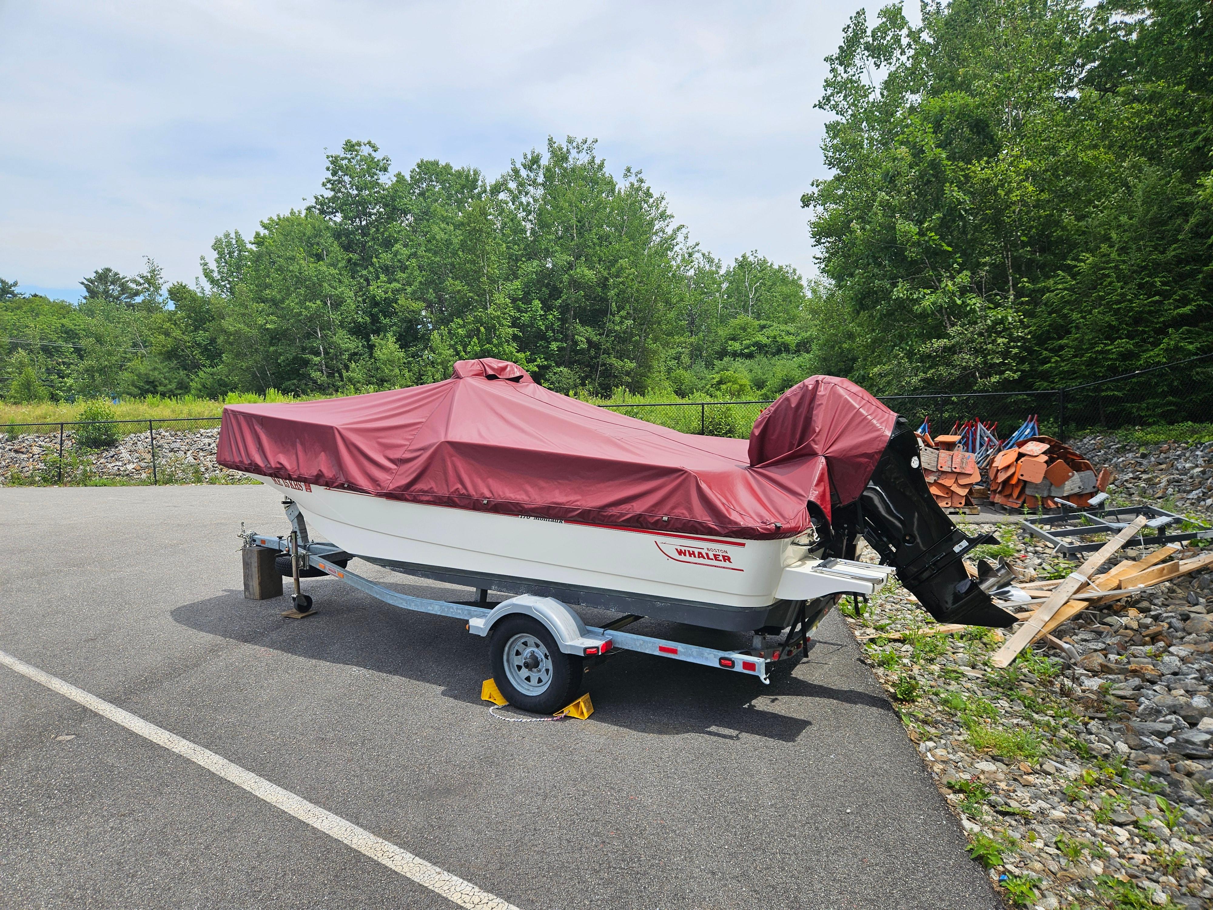 2008 Boston Whaler 170 Montauk boat covered, parked on trailer in outdoor setting.