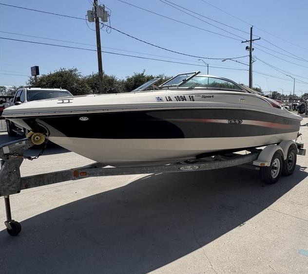 2007 Sea Ray 195 Sport boat on trailer, parked outdoors under clear sky.
