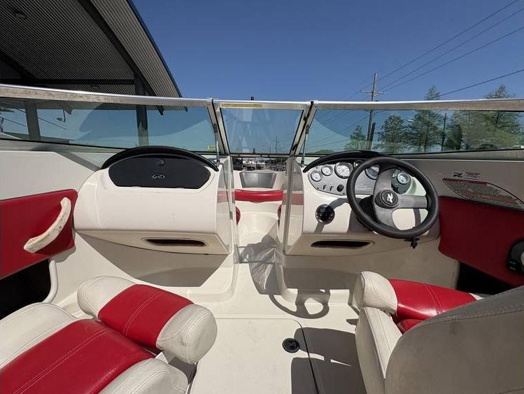 2007 Sea Ray 195 Sport boat interior with red and white seating, steering wheel, and dashboard.