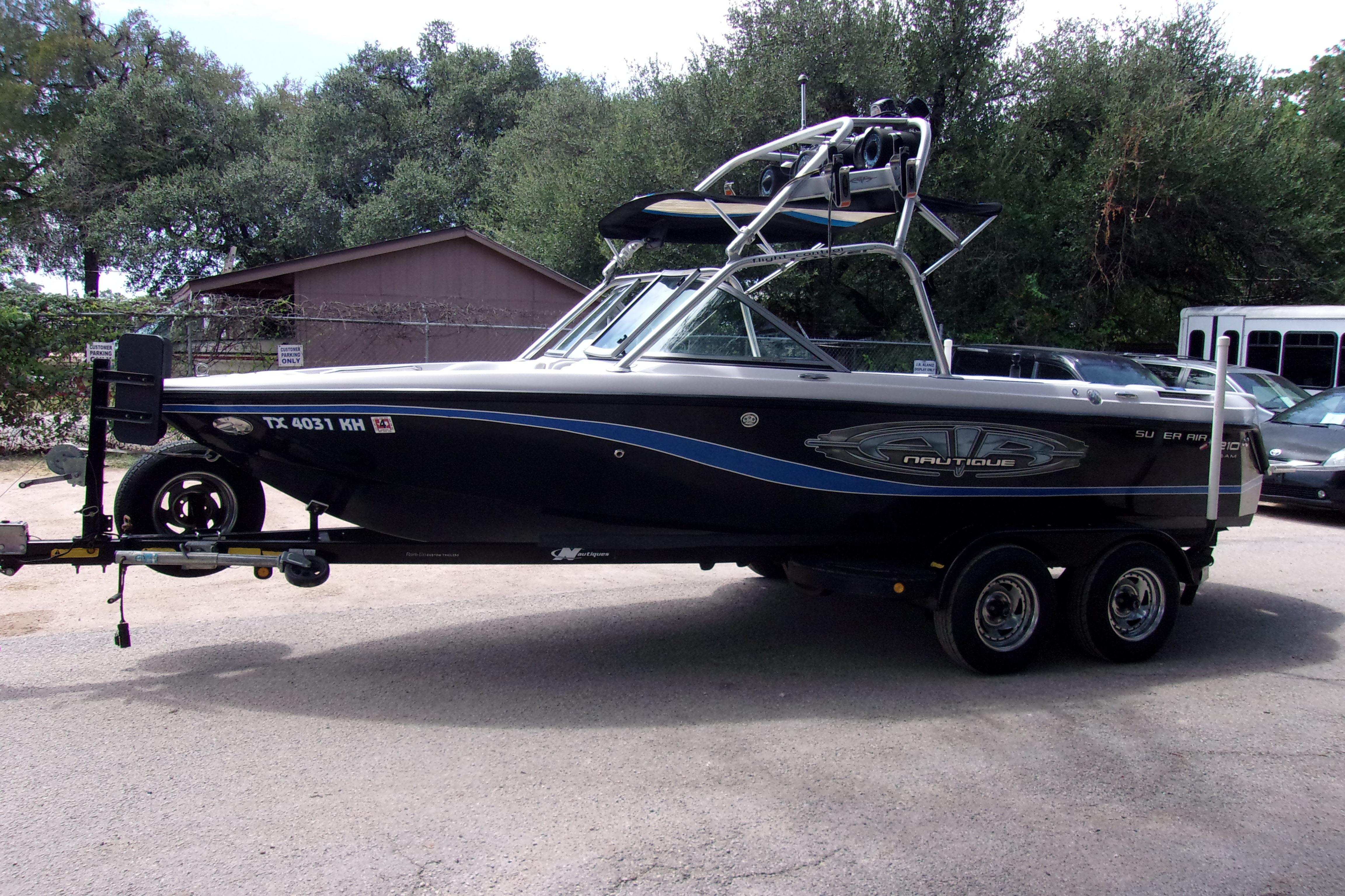 2005 Correct Craft 210 Super Air Team Edition boat on trailer, parked outdoors.