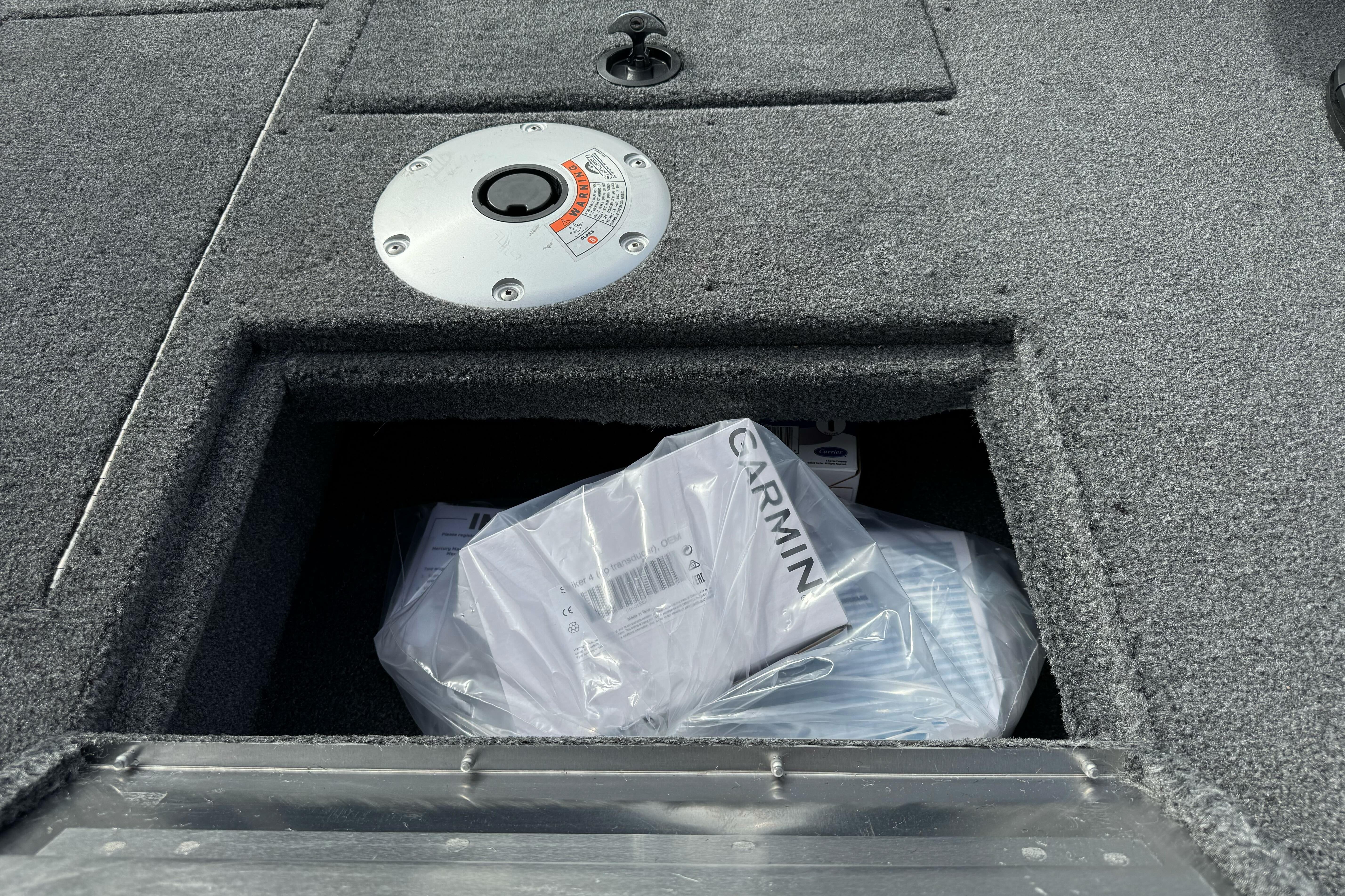 Storage compartment on 2026 Tracker Super Guide V-16 SC boat with Garmin equipment.