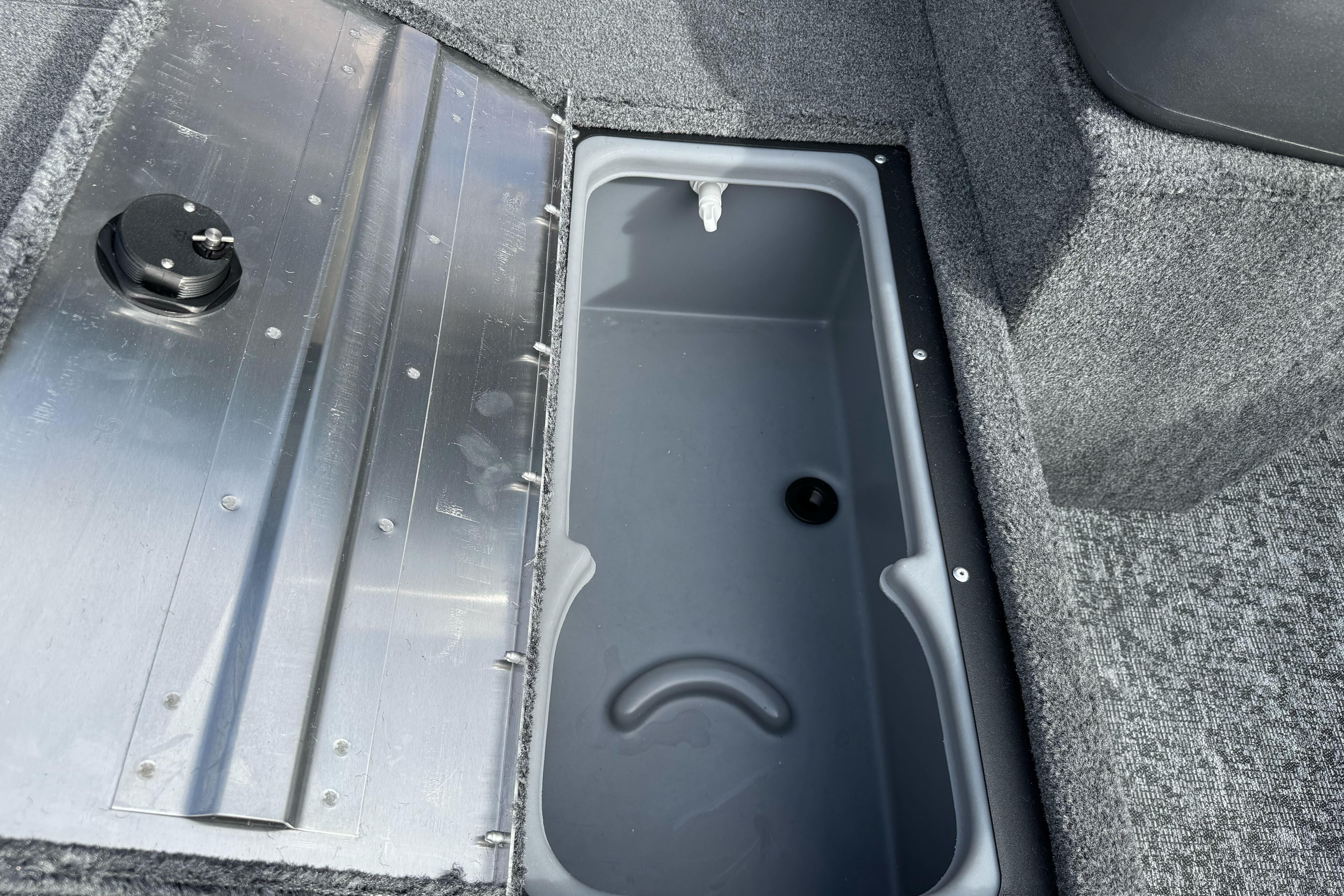 2026 Tracker Super Guide V-16 SC boat storage compartment with gray interior and metal lid.