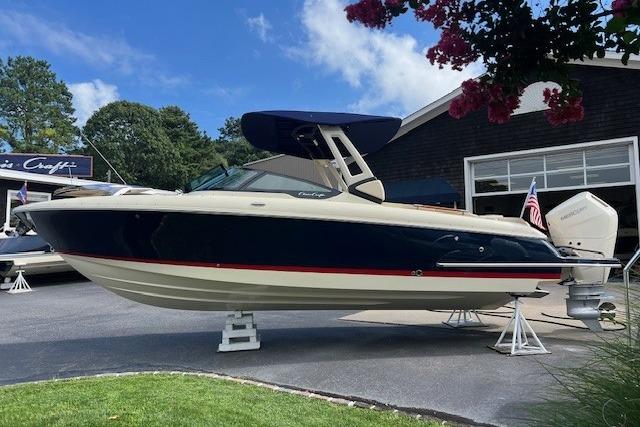2026 Chris-Craft Sportster 28 boat displayed outdoors with blue and cream design.