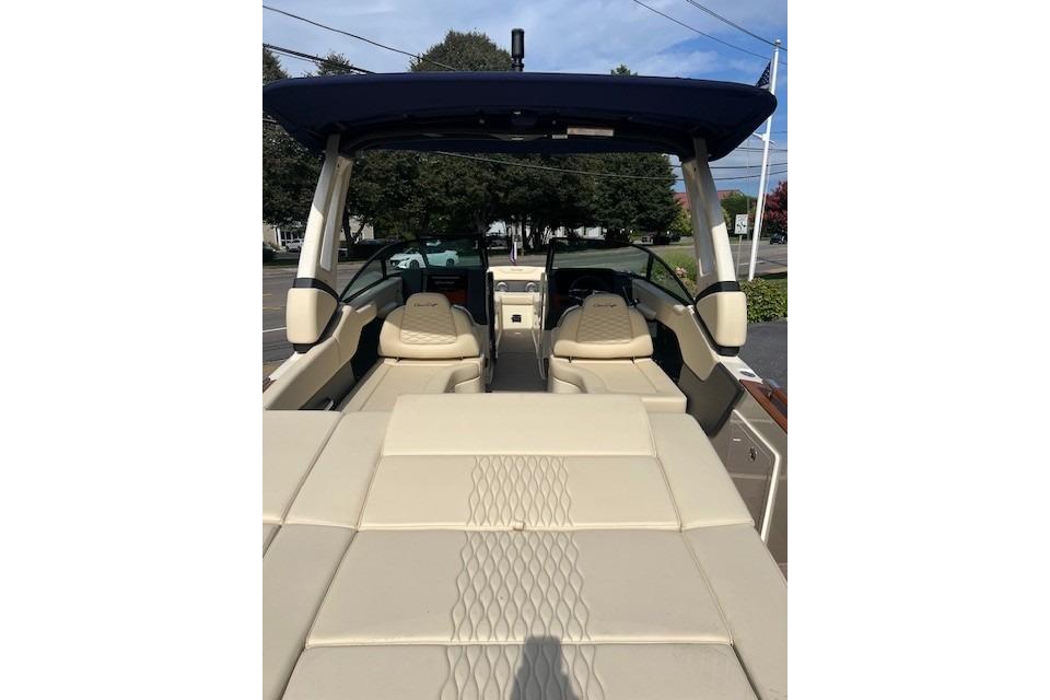 2026 Chris-Craft Sportster 28 boat interior with beige seating and blue canopy.