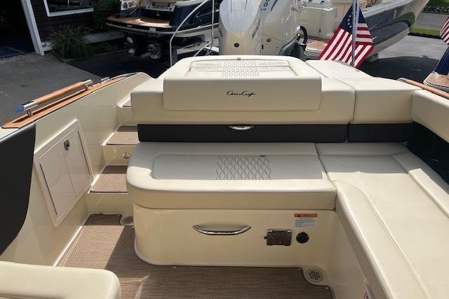 2026 Chris-Craft Sportster 28 boat interior with beige seating and American flags.