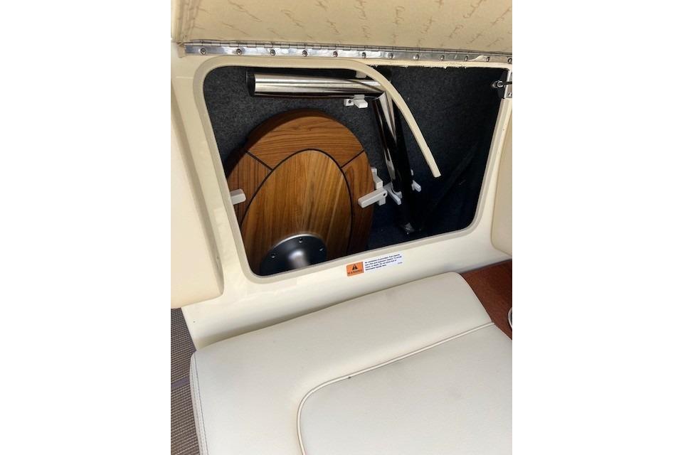 2026 Chris-Craft Sportster 28 interior storage compartment with wooden paneling.