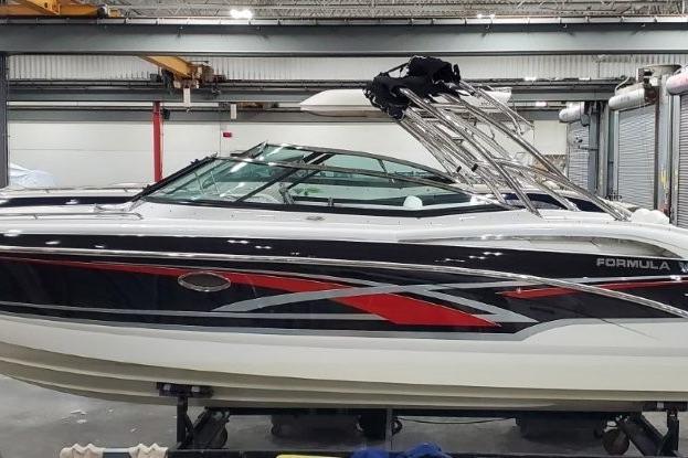 2008 Formula 310 Bowrider boat in a warehouse, featuring sleek design and vibrant graphics.