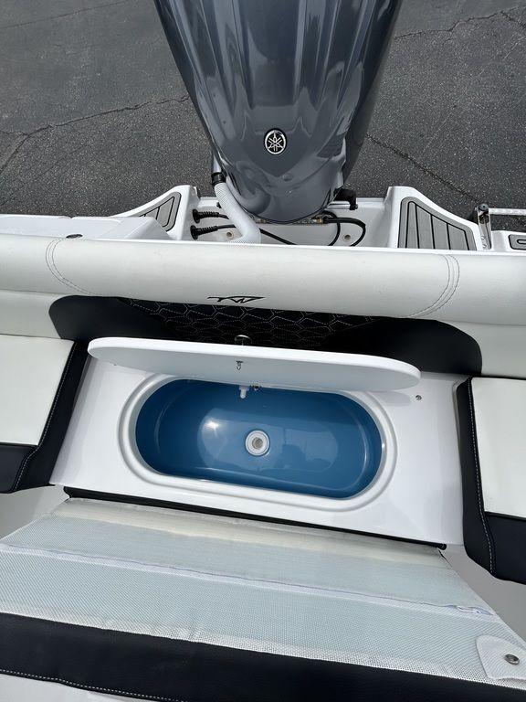 2025 Tidewater 232 LXF boat with open storage compartment and Yamaha engine.