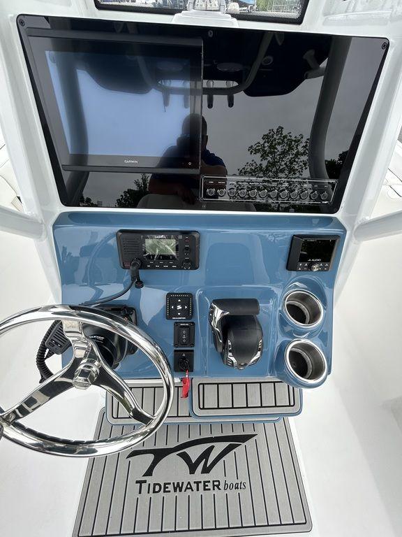 2025 Tidewater 232 LXF boat dashboard with steering wheel and electronic controls.