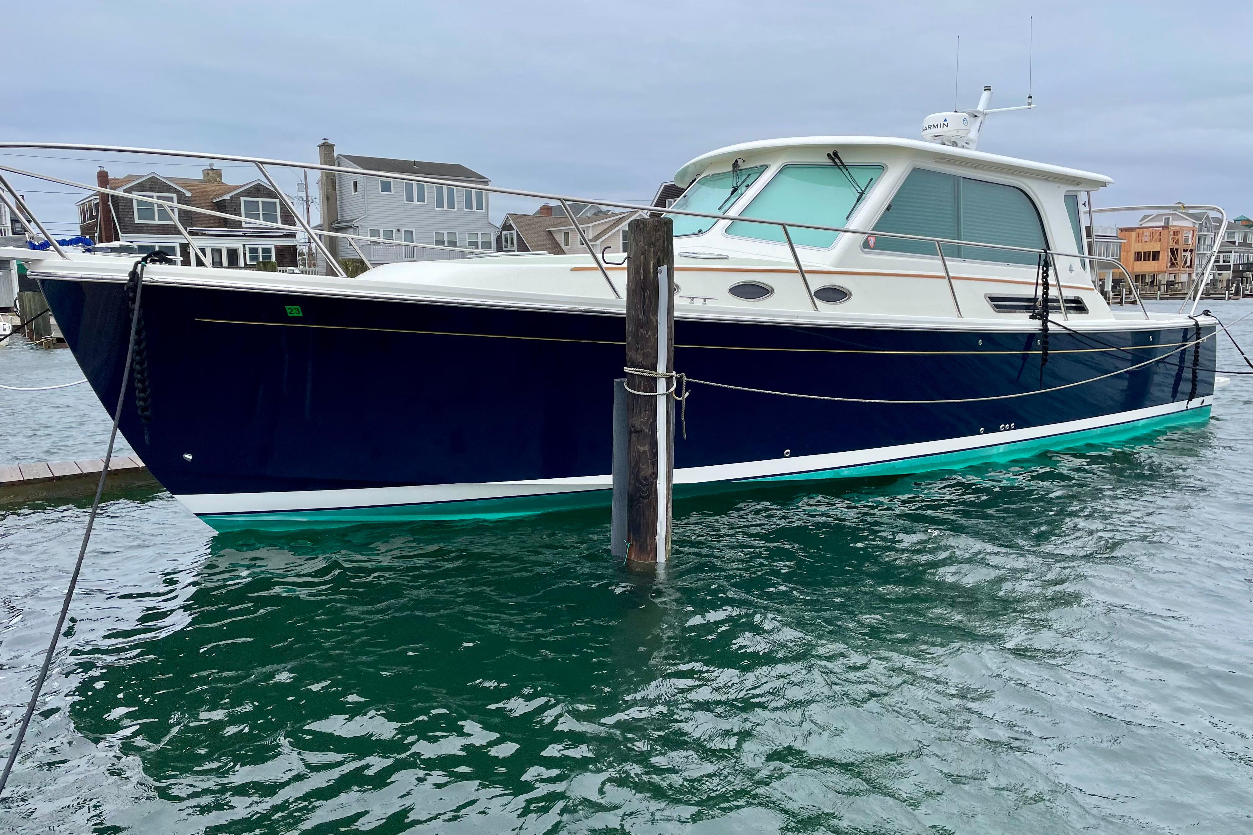 2019 Back Cove 37 boat docked in a marina, featuring a sleek navy hull.