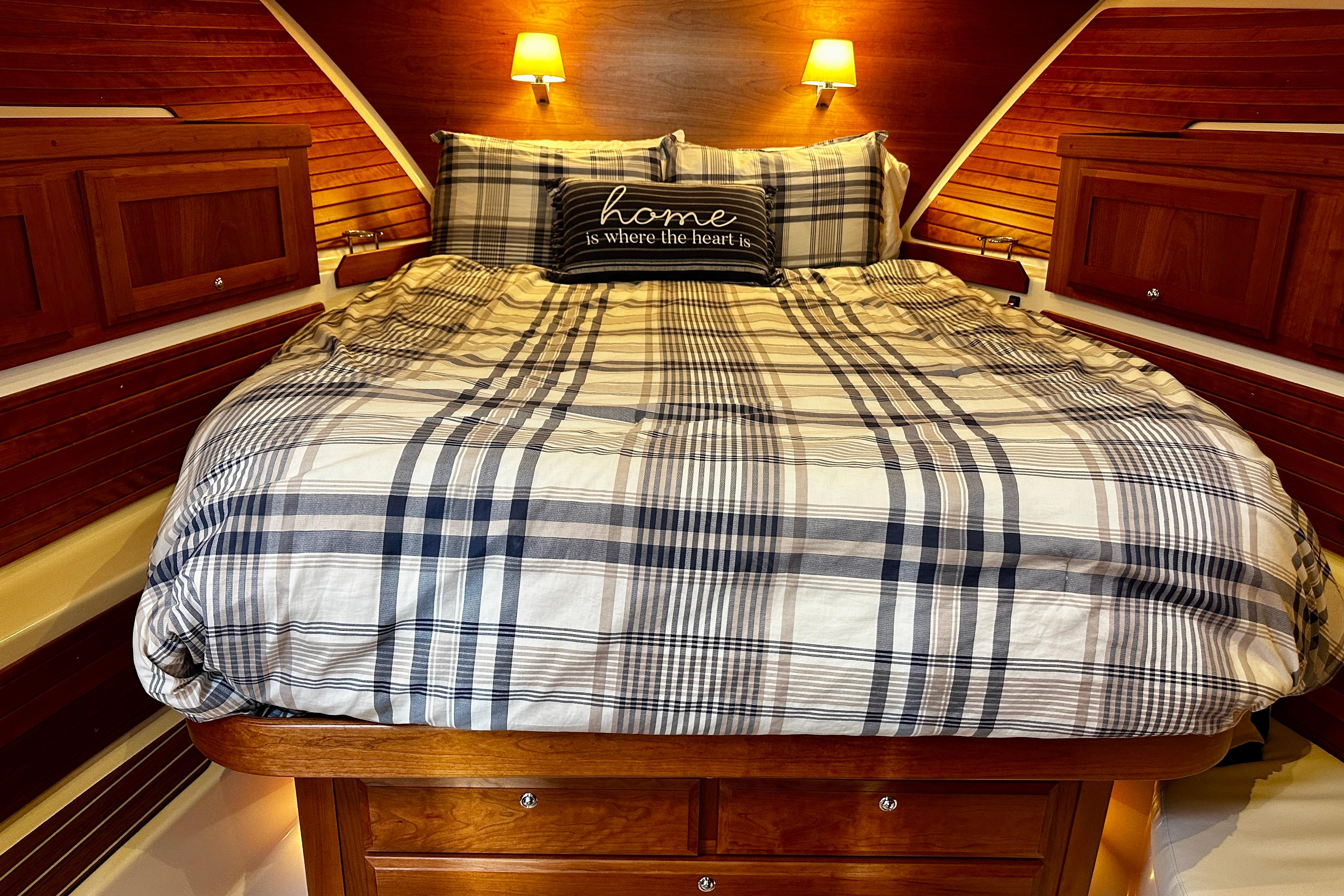 Cozy cabin bedroom in 2019 Back Cove 37 yacht with plaid bedding and warm lighting.