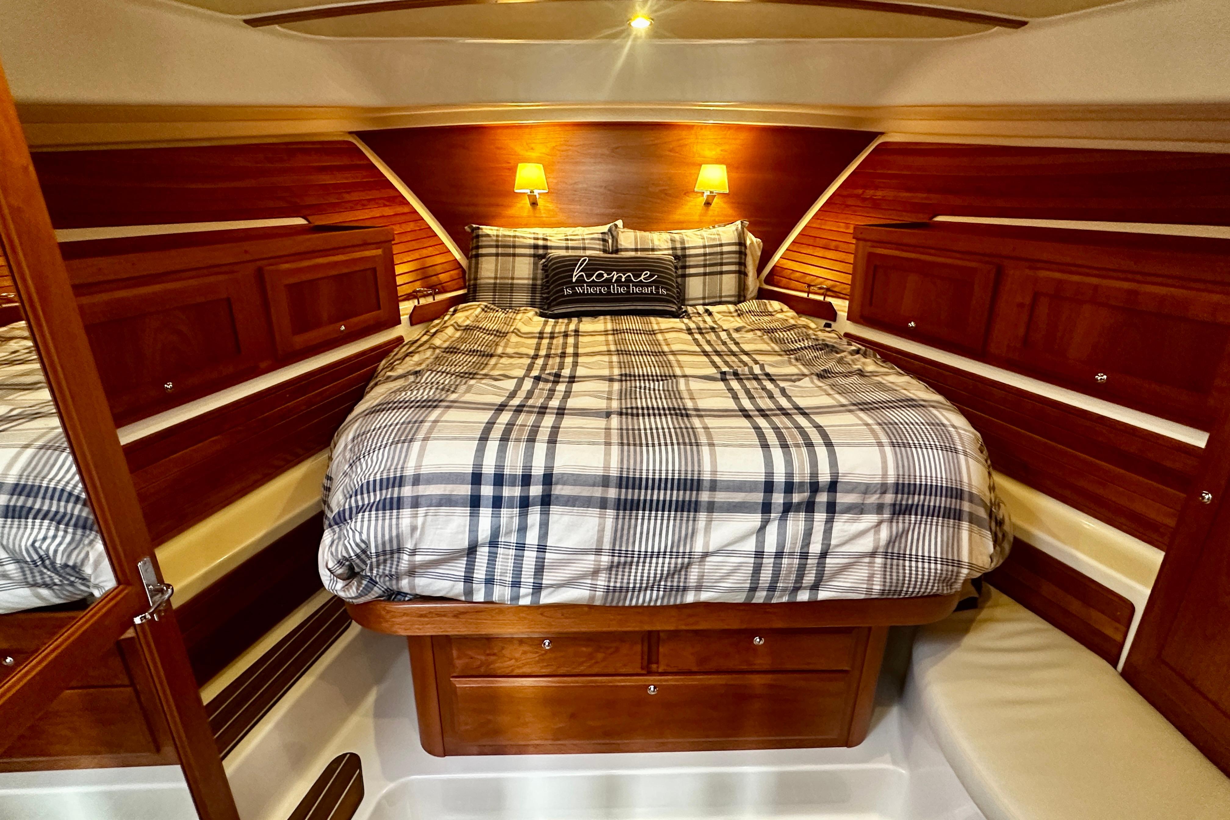Cozy cabin interior of 2019 Back Cove 37 yacht with plaid bedding and warm lighting.