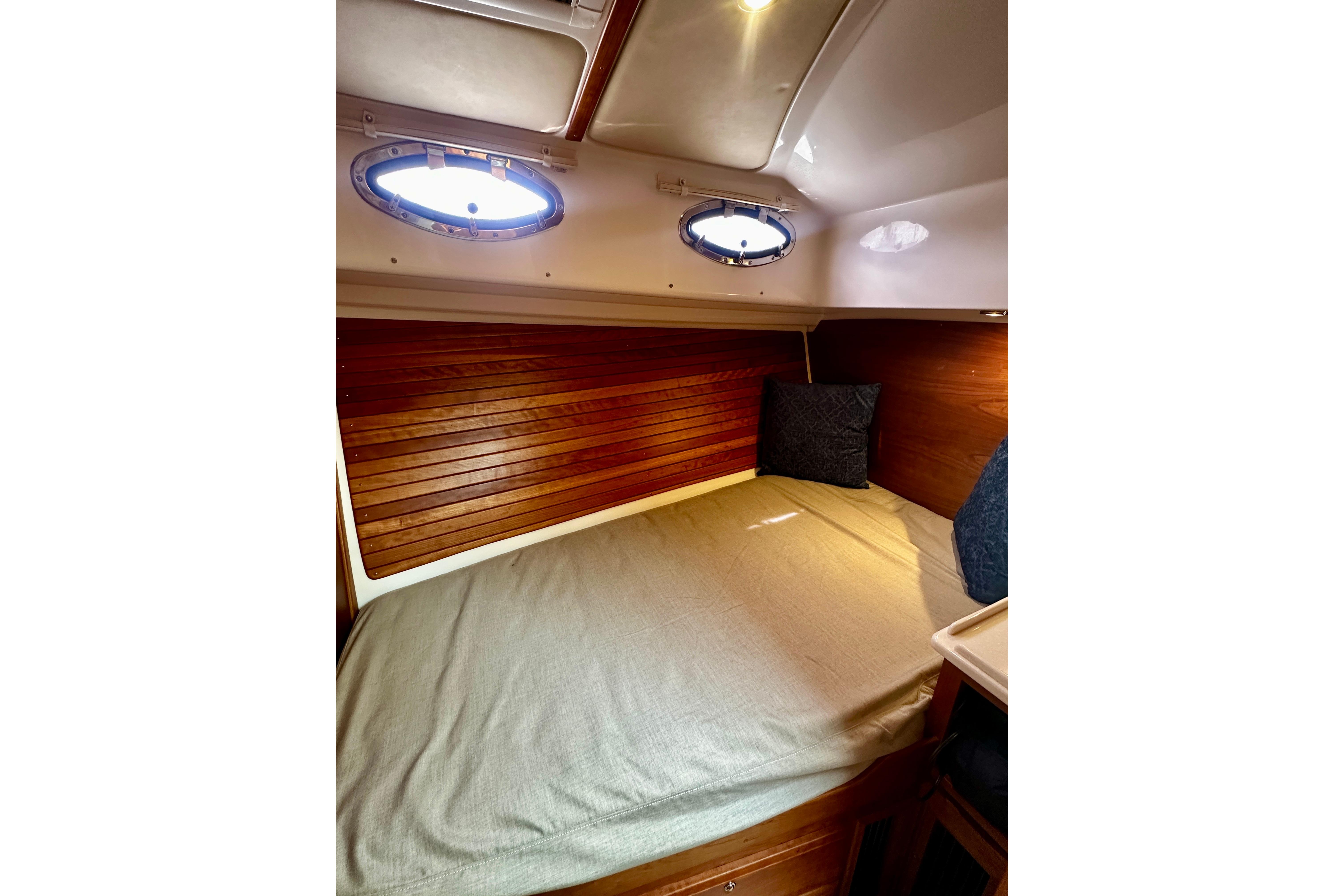 2019 Back Cove 37 cabin interior with wooden paneling and cozy bedding.