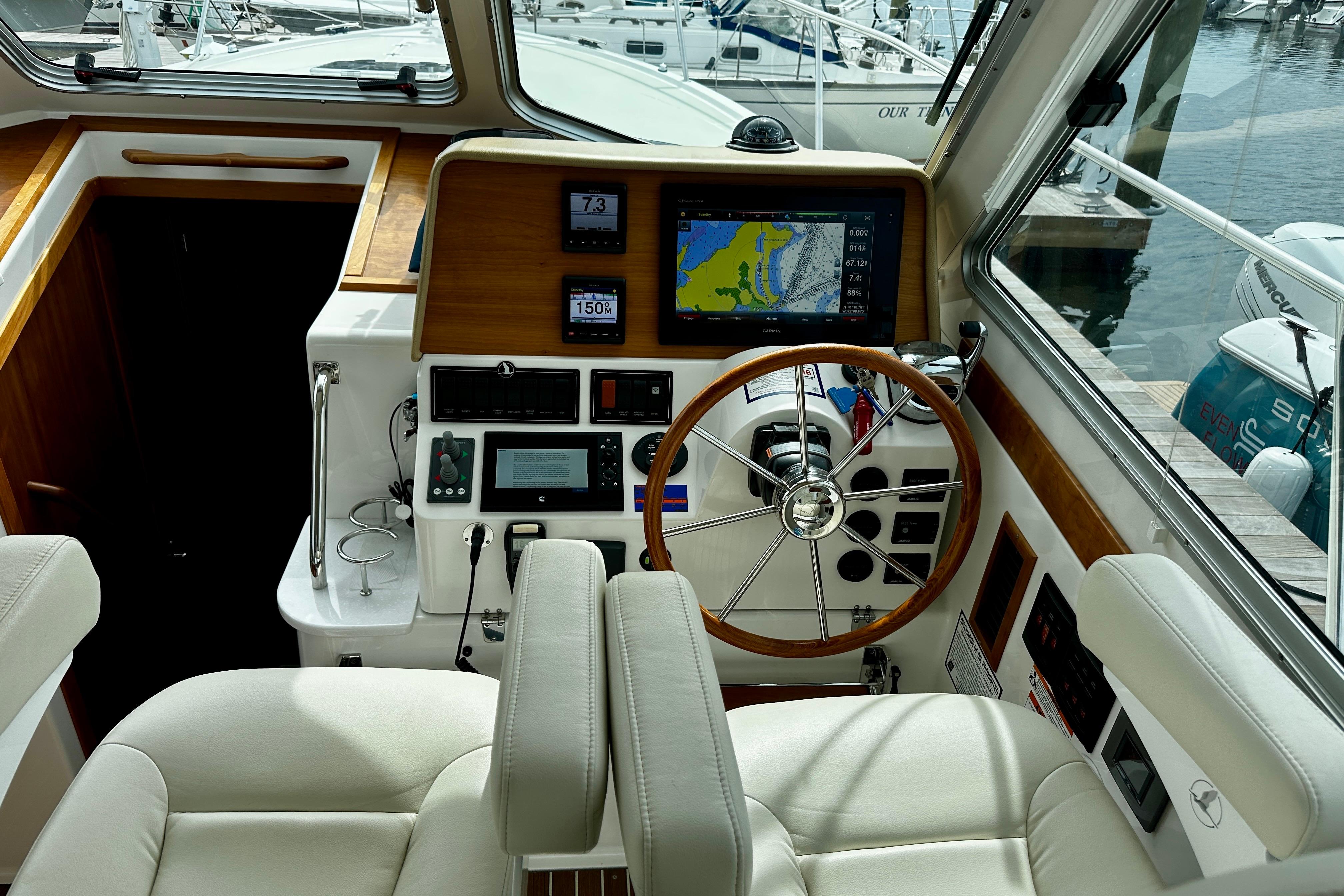 2019 Back Cove 37 yacht helm with navigation system and wooden steering wheel.