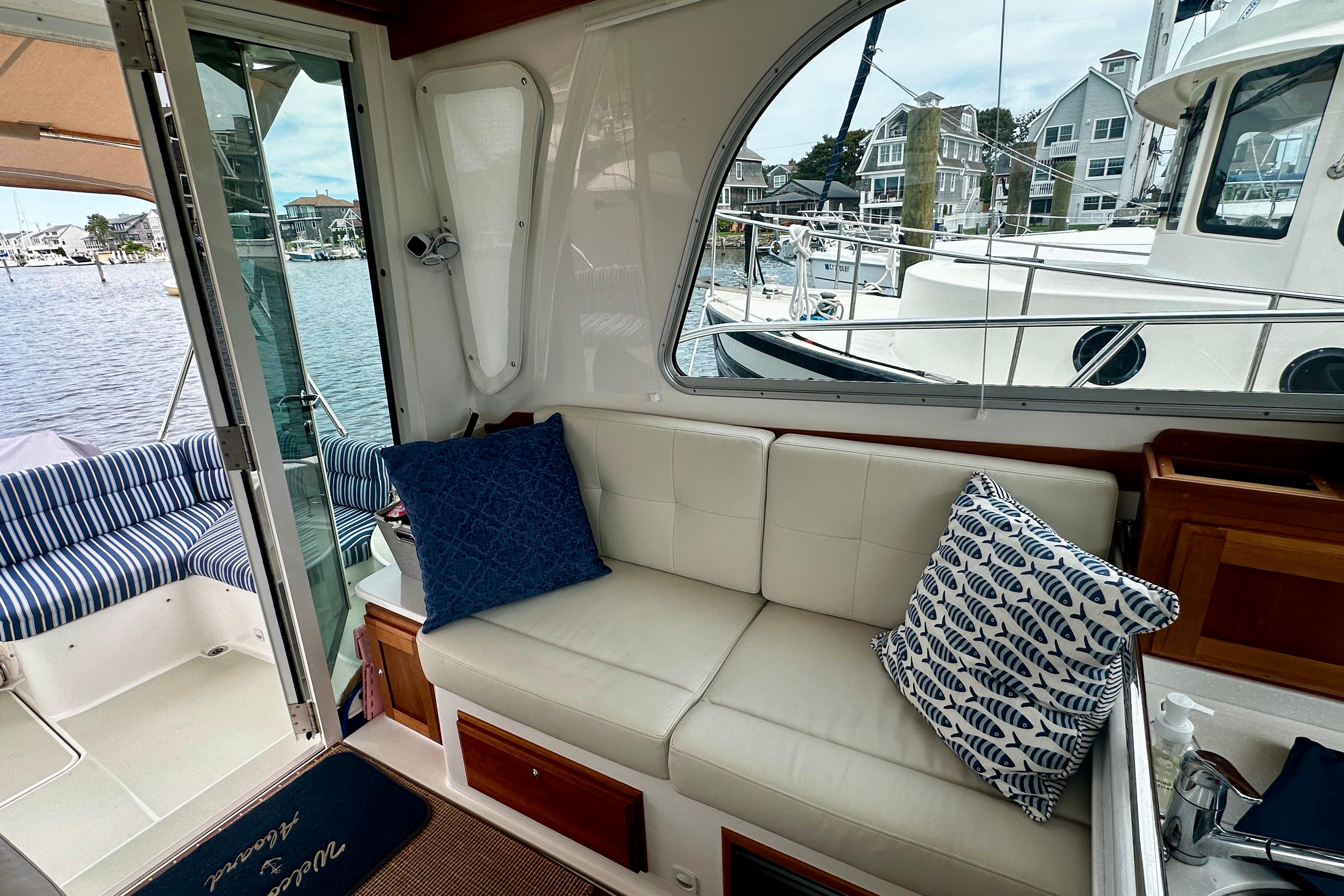 2019 Back Cove 37 yacht interior with comfortable seating and decorative pillows, docked at marina.