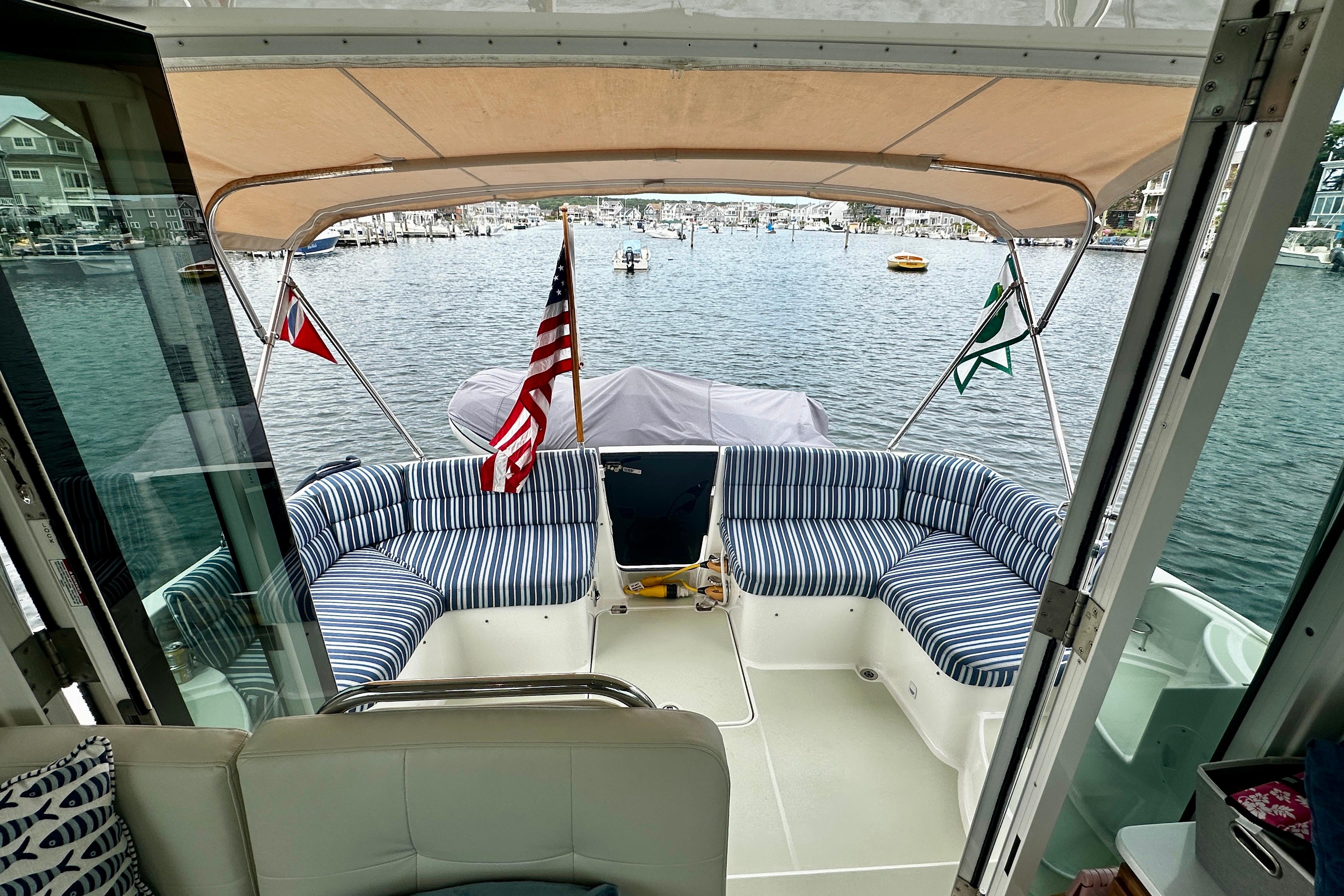 2019 Back Cove 37 yacht with striped seating, docked in a scenic marina.