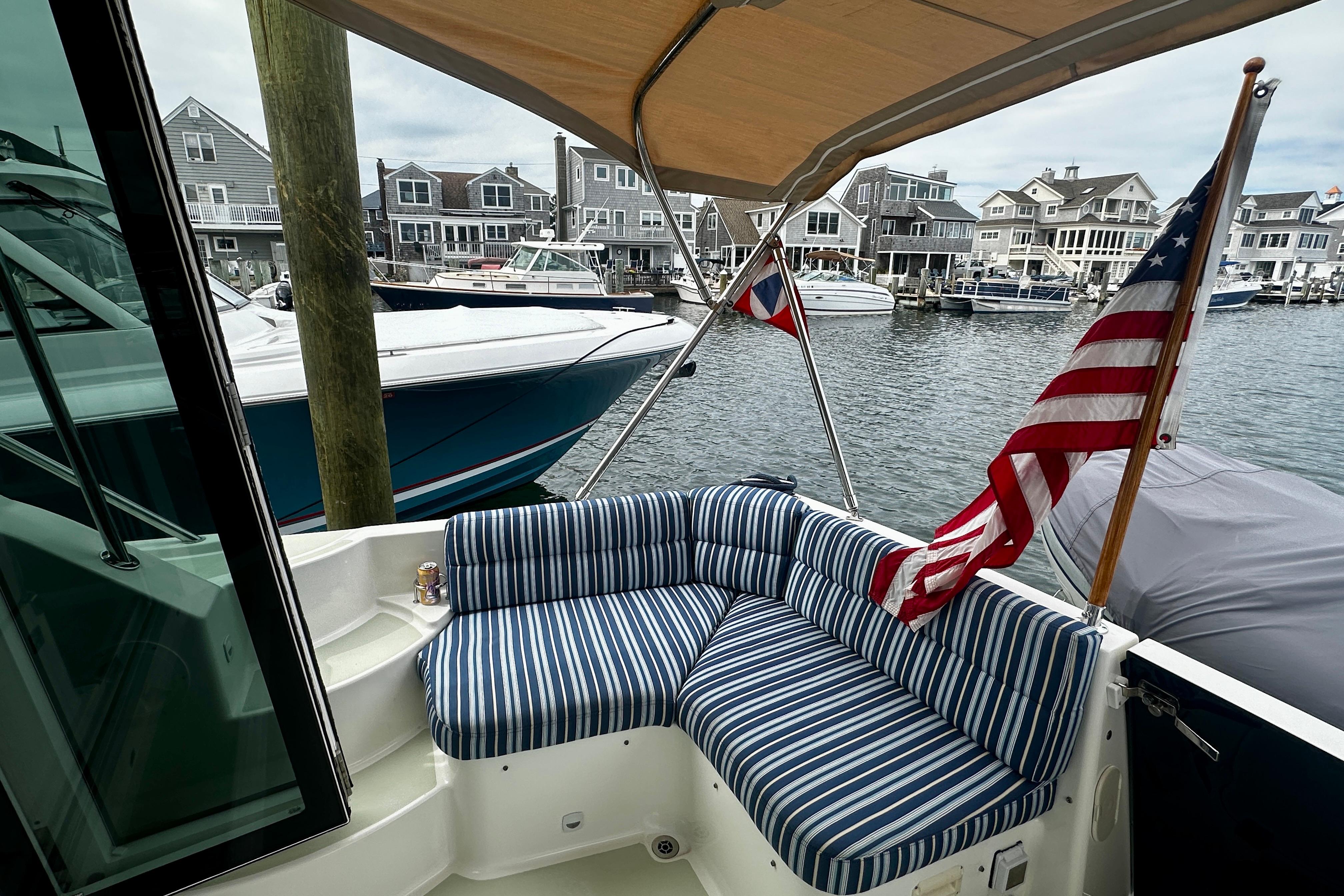2019 Back Cove 37 boat with striped seating, docked in a marina with American flag.