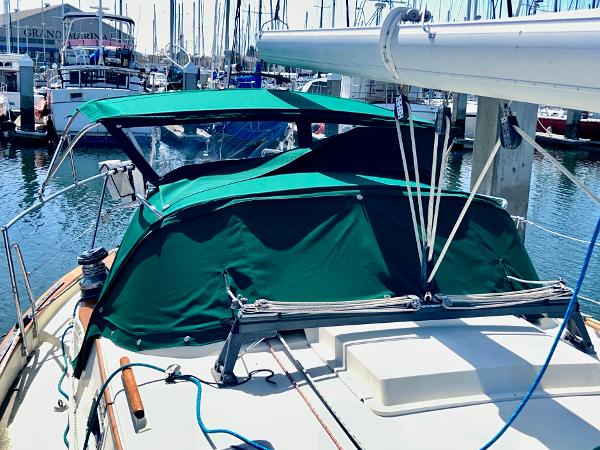 1999 Pacific Seacraft 40 Voyagemaker sailboat docked at marina with green canopy.